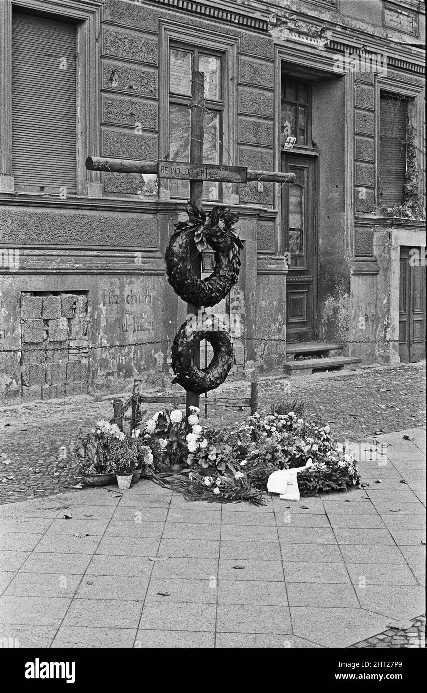 Mémorial à Bernd L¿ser qui est décédé en sautant du toit du 44 Bernauer Strasse suite à la fermeture de la frontière entre Berlin est et Berlin Ouest. Les bâtiments du côté est de la rue sont à Berlin est, et les trottoirs et la rue à Berlin Ouest. Comme cela signifiait qu'un résident pouvait sortir de sa porte d'entrée vers la liberté, les autorités de l'Allemagne de l'est ont ordonné l'évacuation forcée de tous les logements à la frontière et ont bridé toutes les entrées et fenêtres Circa 1965 Banque D'Images