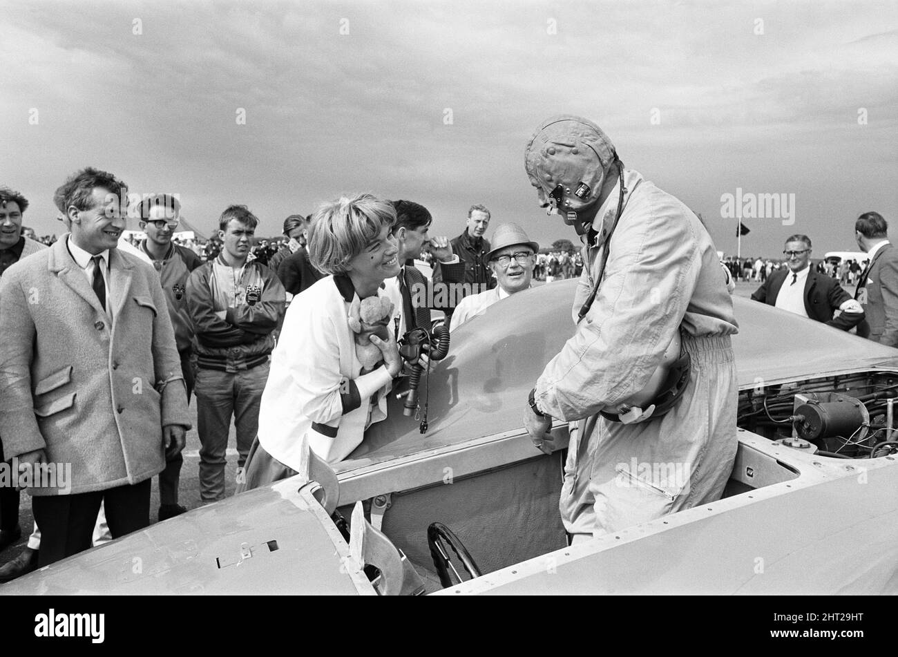 Proteus Bluebird, la voiture dans laquelle Donald Campbell a battu le record mondial de vitesse automobile a maintenant fait sa dernière course, à 5 km/h, à la station RAF, Debden, Essex, 19th juin 1966. Campbell devait faire une démonstration lors d'un gala, Mais 5 jours plus tôt, la voiture a été gravement endommagée quand, avec le pilote de course Peter Bolton aux commandes, elle a heurté une clôture en bois et une haie à 100 km/h, a navigué 10ft dans les airs en traversant la route de Cambridge Chelsford et a finalement tourné sur un terrain de 200 mètres. Également photographié, Tonia Campbell avec des jouets en peluche. Banque D'Images