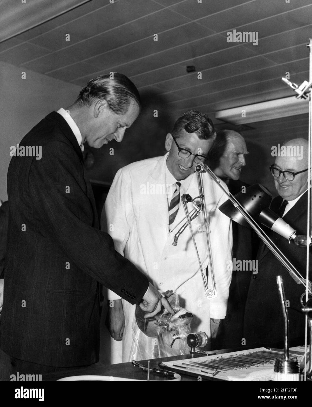 Le prince Philip, duc d'Édimbourg, risque de prendre un doigt lorsqu'il examine un ensemble de dents monté de façon réaliste lors de sa visite de l'école dentaire et de l'hôpital de Heath, Cardiff. Des explications détaillées sont fournies par le Dr J D Eccles, maître de conférences en dentisterie conservatrice. 7th juillet 1966. Banque D'Images