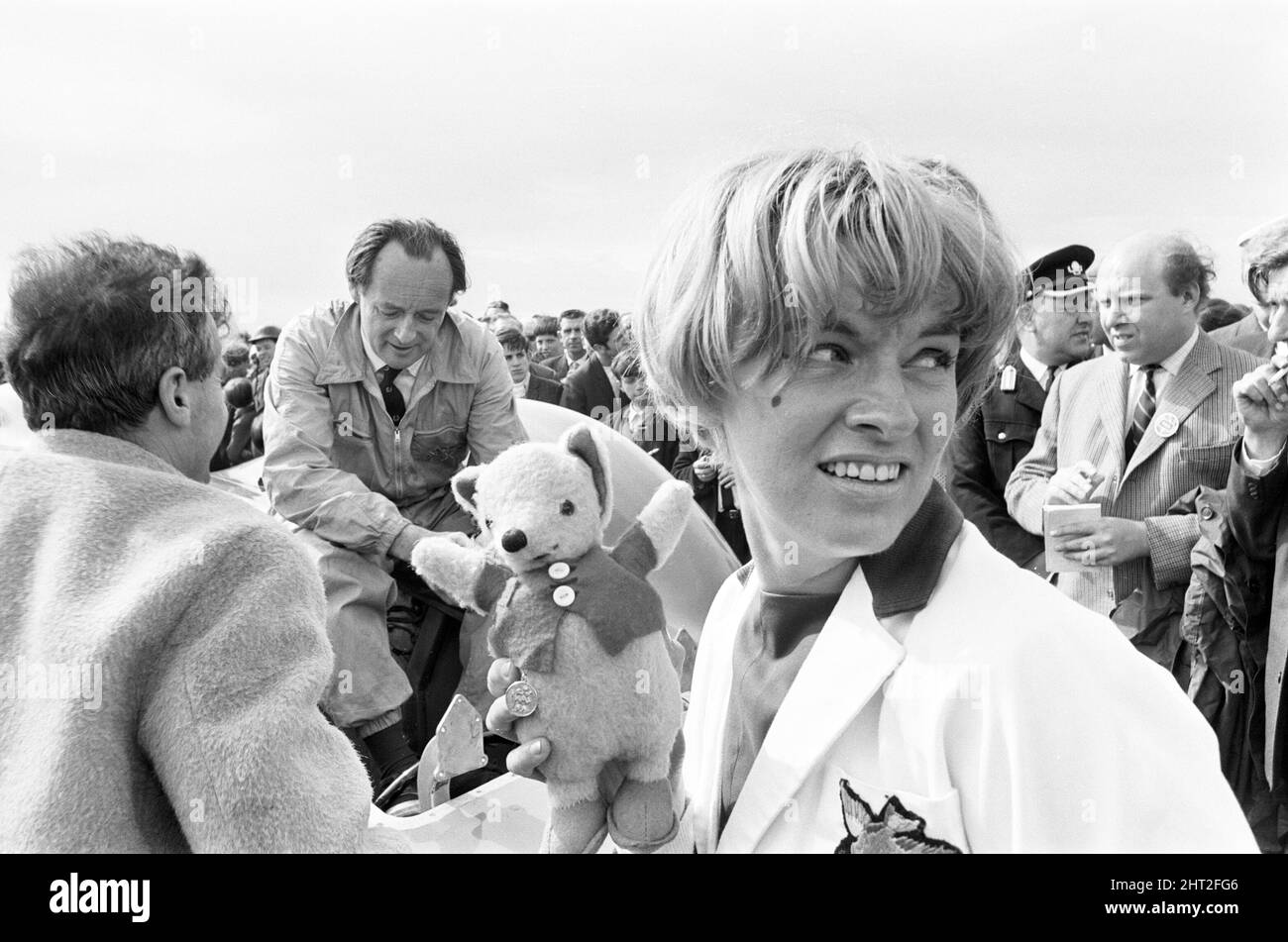Proteus Bluebird, la voiture dans laquelle Donald Campbell a battu le record mondial de vitesse automobile a maintenant fait sa dernière course, à 5 km/h, à la station RAF, Debden, Essex, 19th juin 1966. Campbell devait faire une démonstration lors d'un gala, Mais 5 jours plus tôt, la voiture a été gravement endommagée quand, avec le pilote de course Peter Bolton aux commandes, elle a heurté une clôture en bois et une haie à 100 km/h, a navigué 10ft dans les airs en traversant la route de Cambridge Chelsford et a finalement tourné sur un terrain de 200 mètres. Également en photo, la femme Tonia Campbell. Banque D'Images
