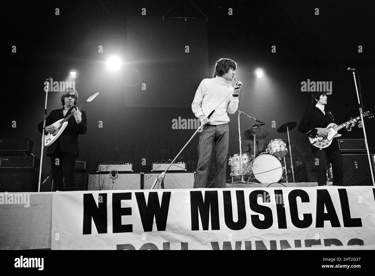 New musical Express Poll Winners concert pop à Empire Pool Wembley, 1965.The Rolling Stones en scène pendant le concert. De gauche à droite : Brian Jones, chanteur Mick Jagger, batteur Charlie Watts (pour la plupart caché) et Keith Richards. The Stones a remporté le prix du meilleur groupe R & B britannique ainsi que le meilleur nouveau disque de l'année pour sa seule satisfaction (je ne peux pas obtenir non). 11th avril 1965. Banque D'Images