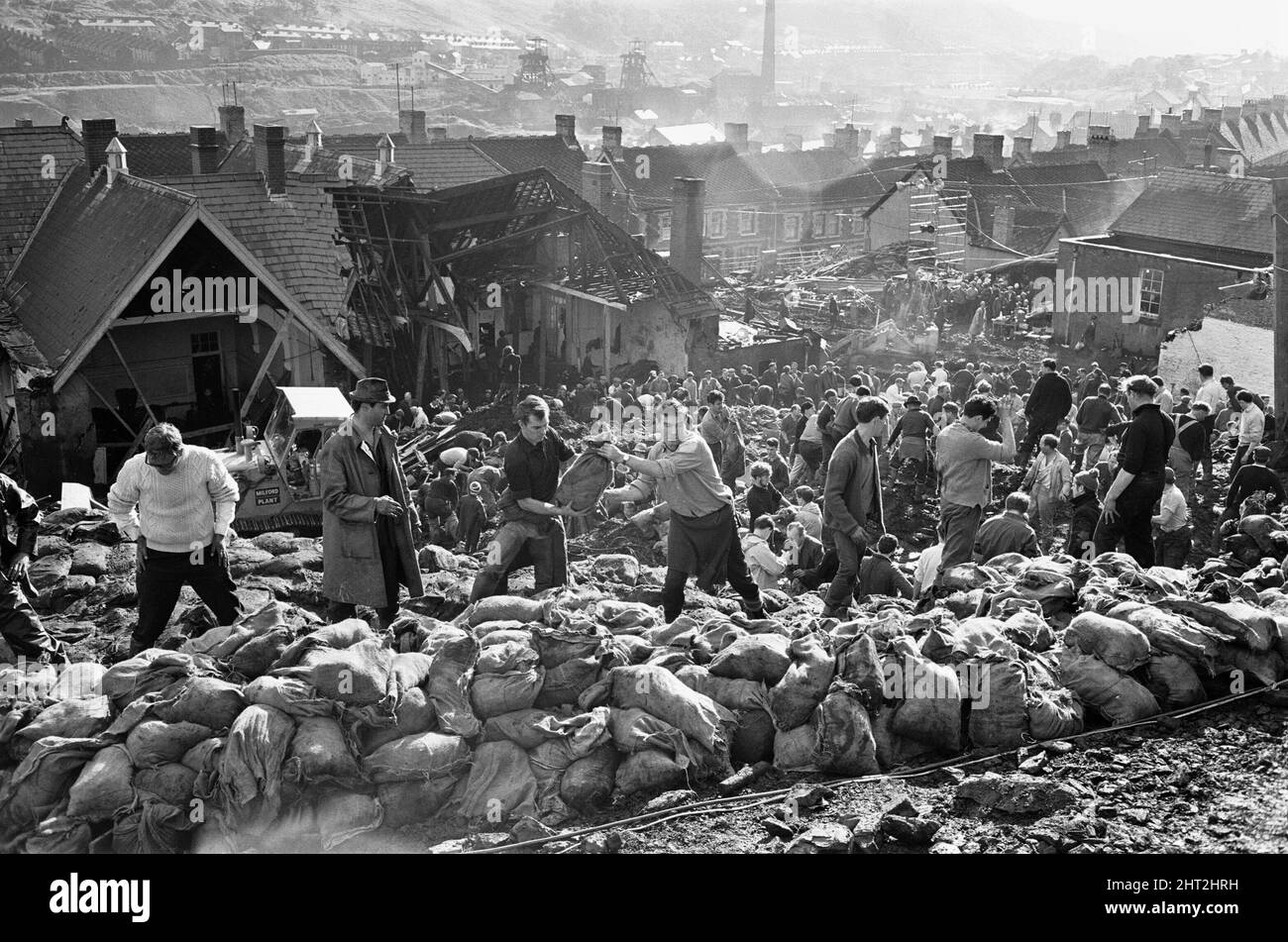 Des secouristes ensachent et déplacent une partie des butin de charbon suite à l'effondrement catastrophique d'un bout de butin de colliery dans le village gallois d'Aberfan, près de Merthyr Tydfil, le 21 octobre 1966. Le glissement de terrain de 40 000 mètres cubes de lisier a englouti le village et la Pantansa Junior School, tuant 116 enfants et 28 adultes. Elle a été causée par une accumulation d'eau dans la roche et le schiste sur la pointe de butin de colliery local, qui a soudainement commencé à glisser en descente sous forme de lisier.les événements du vendredi, 21 octobre 1966 Pointe no 7, qui était à 500 pieds au-dessus du village d'Aberfan, près de Merth Banque D'Images