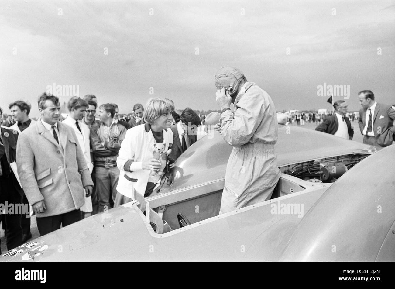 Proteus Bluebird, la voiture dans laquelle Donald Campbell a battu le record mondial de vitesse automobile a maintenant fait sa dernière course, à 5 km/h, à la station RAF, Debden, Essex, 19th juin 1966. Campbell devait faire une démonstration lors d'un gala, Mais 5 jours plus tôt, la voiture a été gravement endommagée quand, avec le pilote de course Peter Bolton aux commandes, elle a heurté une clôture en bois et une haie à 100 km/h, a navigué 10ft dans les airs en traversant la route de Cambridge Chelsford et a finalement tourné sur un terrain de 200 mètres. Également photographié, Tonia Campbell tenant des jouets en peluche. Banque D'Images