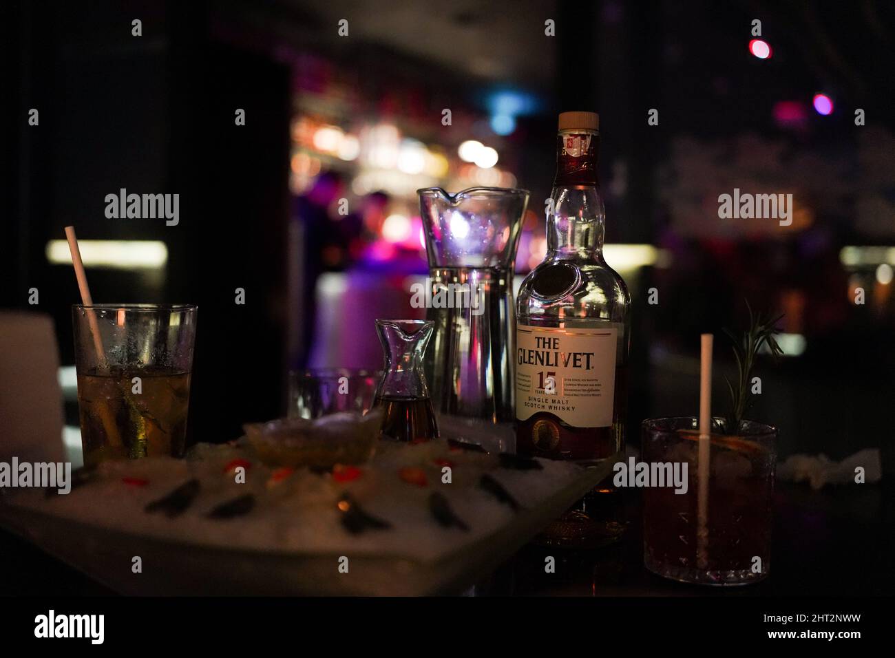 Gros plan d'un whisky avec des verres dans un bar aux néons à Macao, Chine Banque D'Images