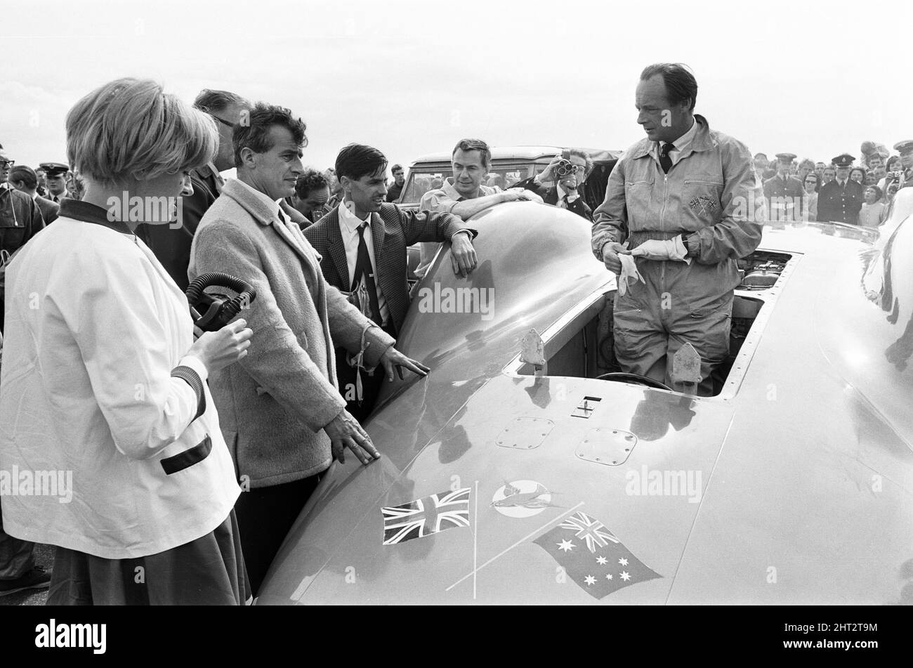 Proteus Bluebird, la voiture dans laquelle Donald Campbell a battu le record mondial de vitesse automobile a maintenant fait sa dernière course, à 5 km/h, à la station RAF, Debden, Essex, 19th juin 1966. Campbell devait faire une démonstration lors d'un gala, Mais 5 jours plus tôt, la voiture a été gravement endommagée quand, avec le pilote de course Peter Bolton aux commandes, elle a heurté une clôture en bois et une haie à 100 km/h, a navigué 10ft dans les airs en traversant la route de Cambridge Chelsford et a finalement tourné sur un terrain de 200 mètres. Également en photo, la femme Tonia Campbell. Banque D'Images