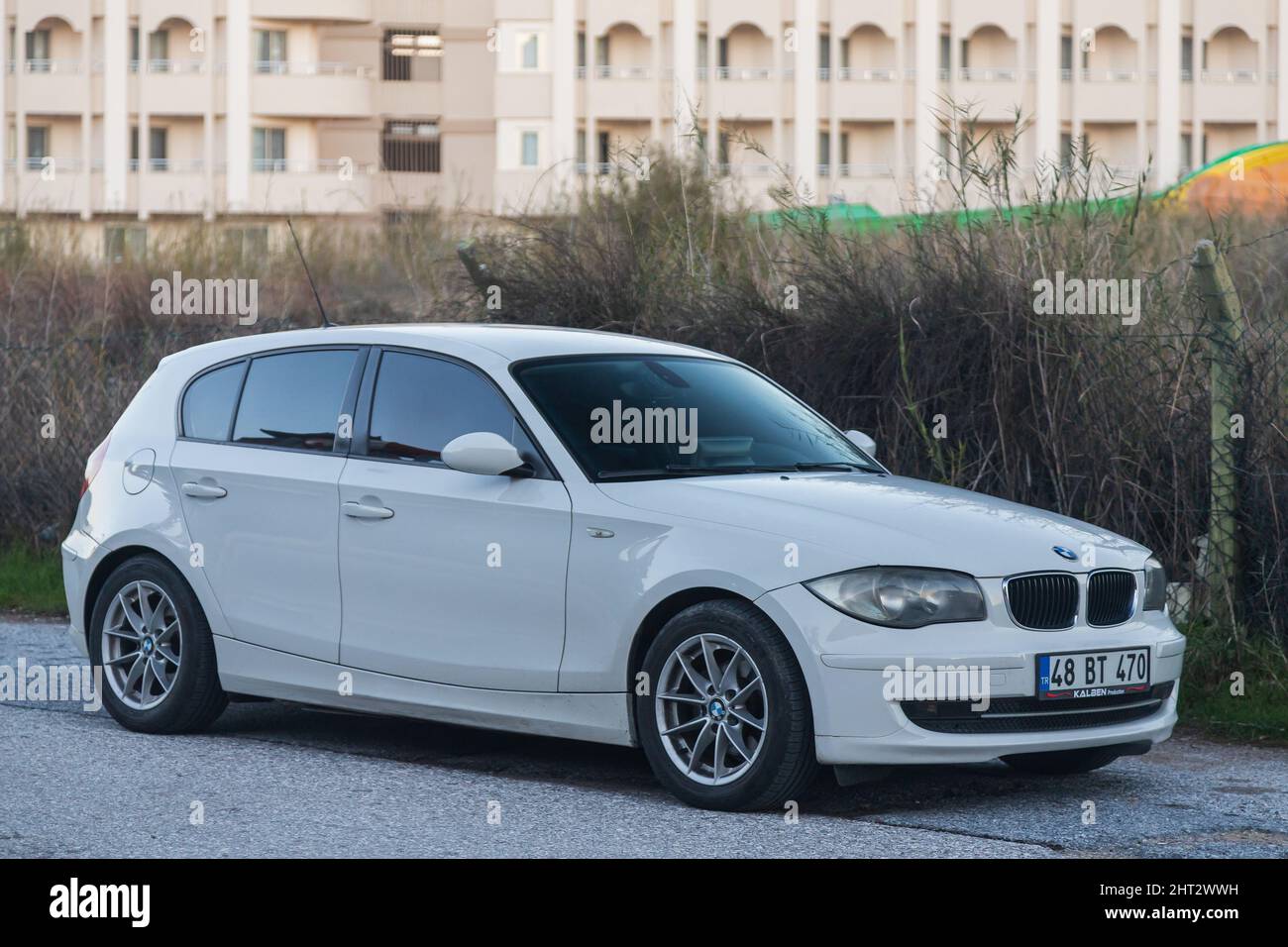 Side, Turquie – 02 2022 février : la BMW série 1 blanche est garée dans la rue par une chaude journée d'automne sur fond de rue Banque D'Images