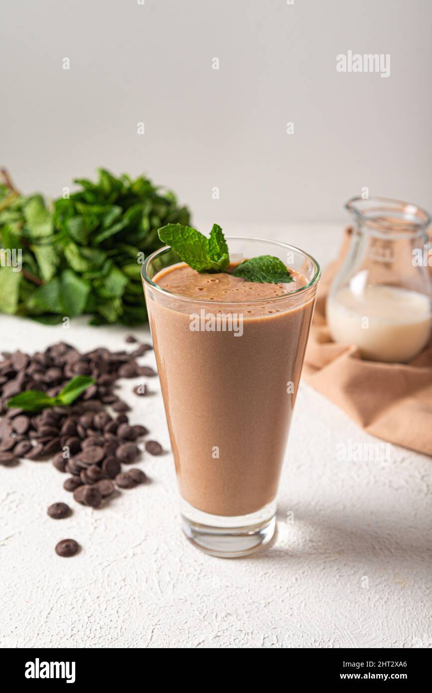 milk-shake aux protéines de chocolat dans un fond de cuisine blanc en verre. milk-shake au chocolat délicieux portion. milk-shake aux protéines saines sur le lait végétalien Banque D'Images