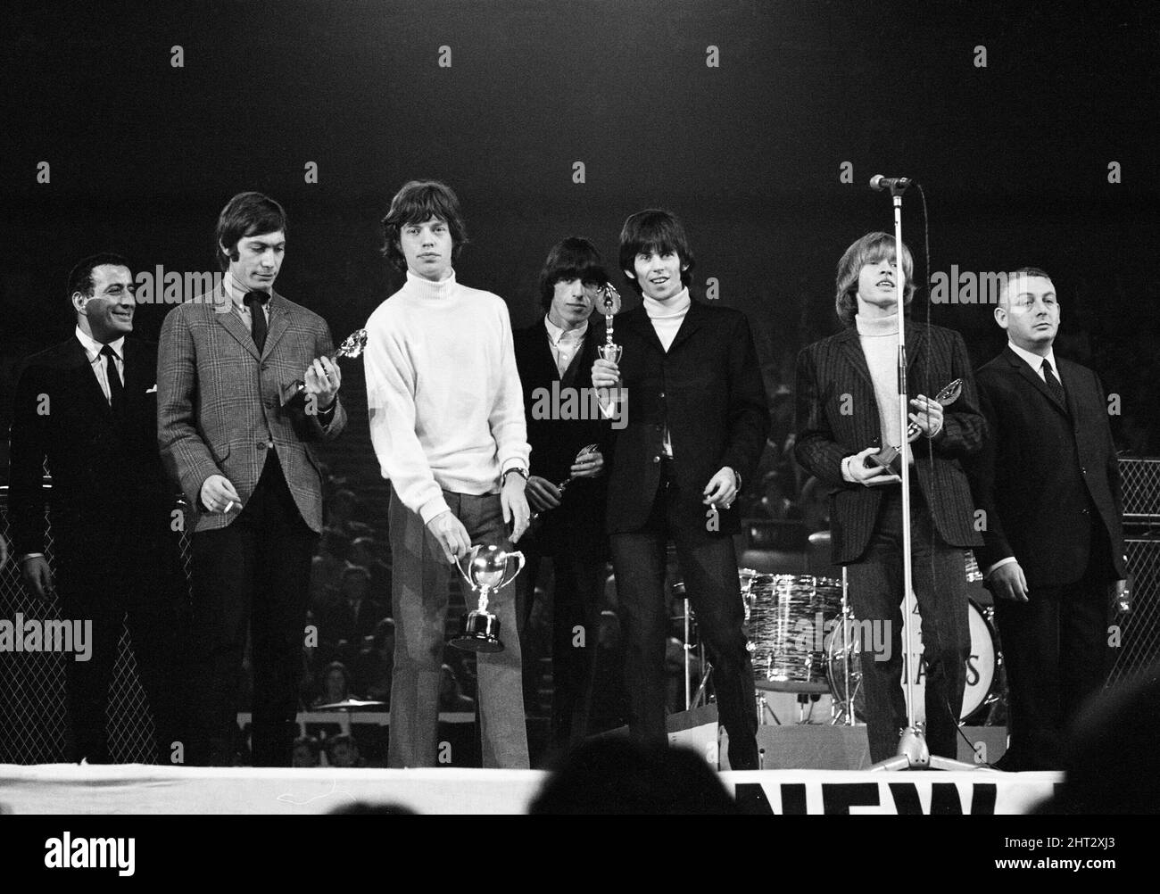 New musical Express Poll Winners concert pop à Empire Pool Wembley, 1965.The Rolling Stones en scène pendant le concert. De gauche à droite : Brian Jones, chanteur Mick Jagger, batteur Charlie Watts (pour la plupart caché) et Keith Richards. The Stones a remporté le prix du meilleur groupe R & B britannique ainsi que le meilleur nouveau disque de l'année pour sa seule satisfaction (je ne peux pas obtenir non). Le groupe est représenté ici avec ses récompenses. 11th avril 1965. Banque D'Images