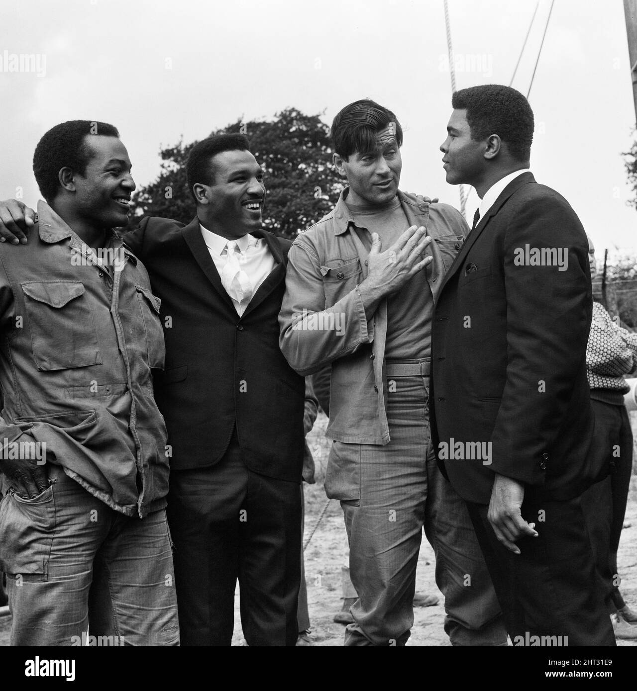 Muhammad Ali (Cassius Clay), a pris une pause avant son combat de titre prochain avec Brian Londres. Clay a rendu visite à l'ensemble du film de Beechwood Park School, Markyate, Hertfordshire. Où MGN filmait des séquences de « la sale douzaine ». (Photo) Jim Brown, frère d'Ali et directeur Clint Walker G.I. avec Muhammad Ali. 6th août 1966 Banque D'Images