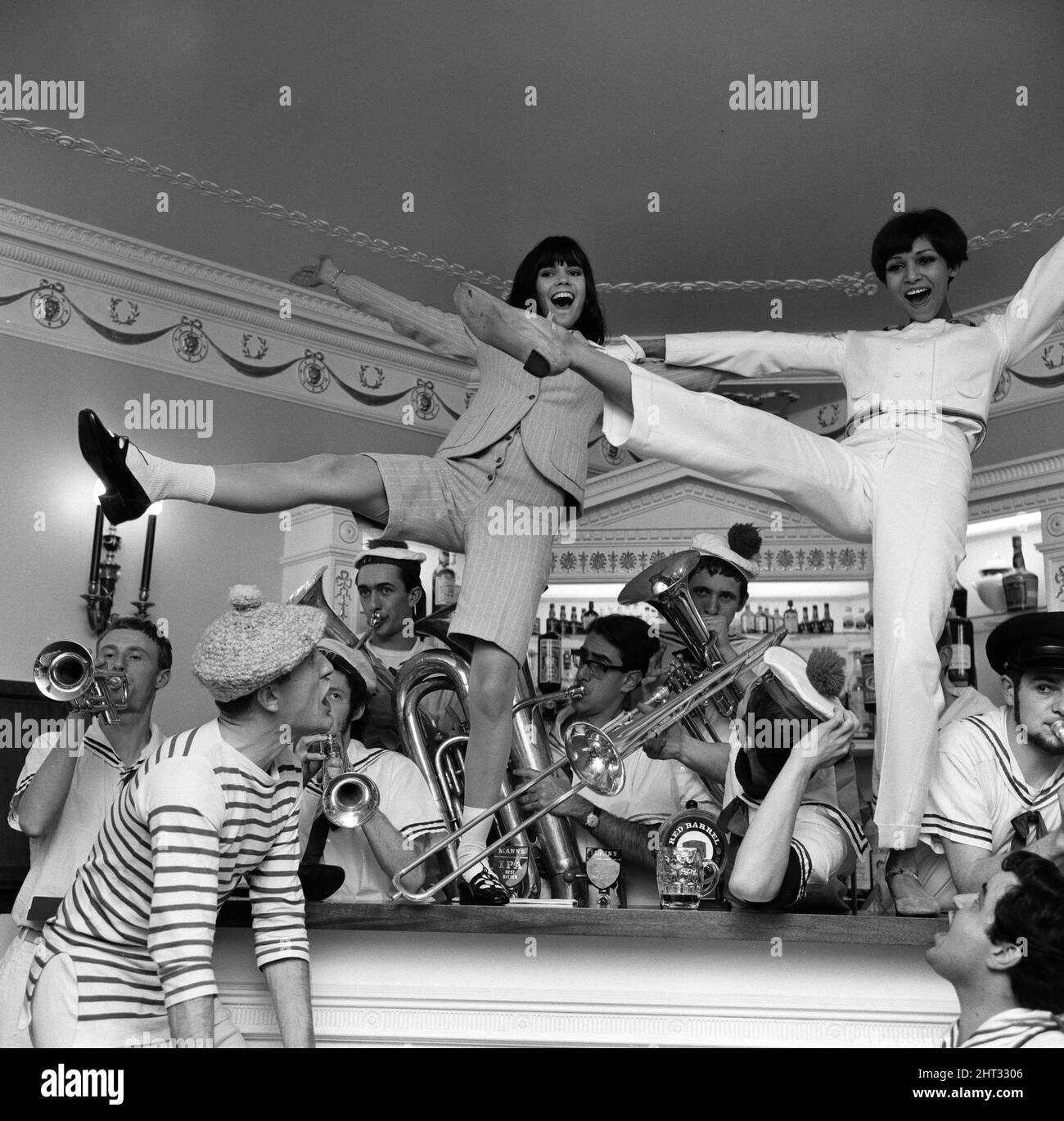 Chantal Goya, (danse sur scène, à gauche) jeune pop-star française photographiée au salon des designers de vêtements français Bagatel à la Trafalgar Tavern de Greenwich, Londres. Photo prise le 18th novembre 1965. Chantal porte un costume de culotte en flanelle anglais vert à rayures sauge. Banque D'Images