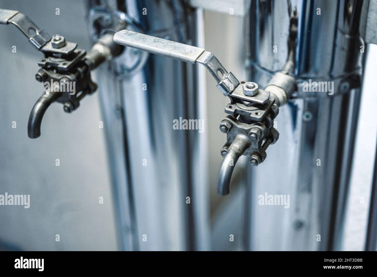 Canalisations minces avec leviers bleus ouverts et fermés à l'usine Banque D'Images