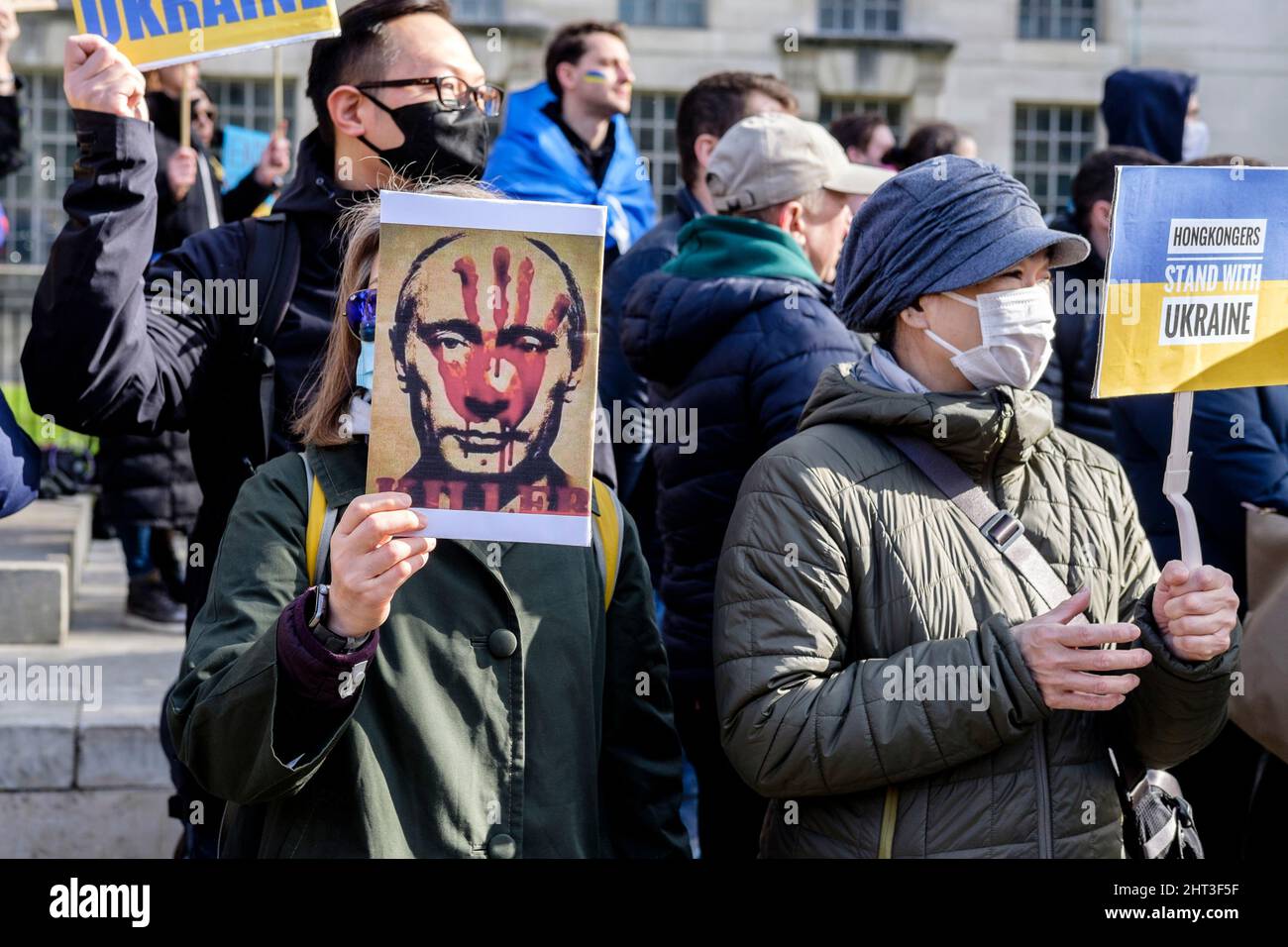 26th février 2022 : des ressortissants ukrainiens et des partisans pro-ukrainiens se rassemblent à Whitehall pour protester contre l'invasion russe de l'Ukraine. Londres, Royaume-Uni. En photo : une femme porte un écriteau avec une image du président russe Poutine avec une main sanglante imprimée sur son visage. Banque D'Images