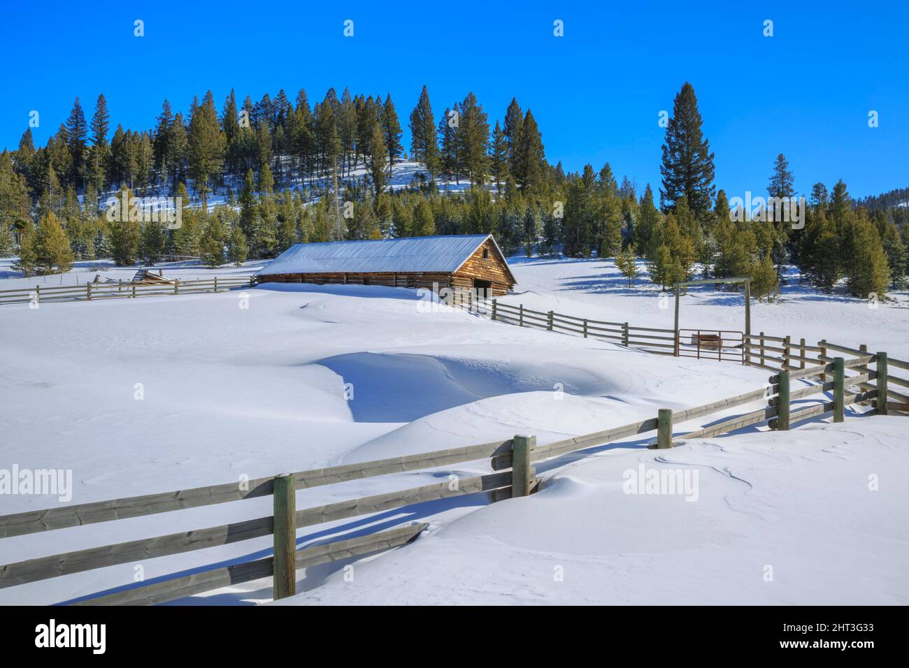 une ancienne grange en rondins et de profondes dérives de neige dans la vallée de dog creek près d'elliston, montana Banque D'Images
