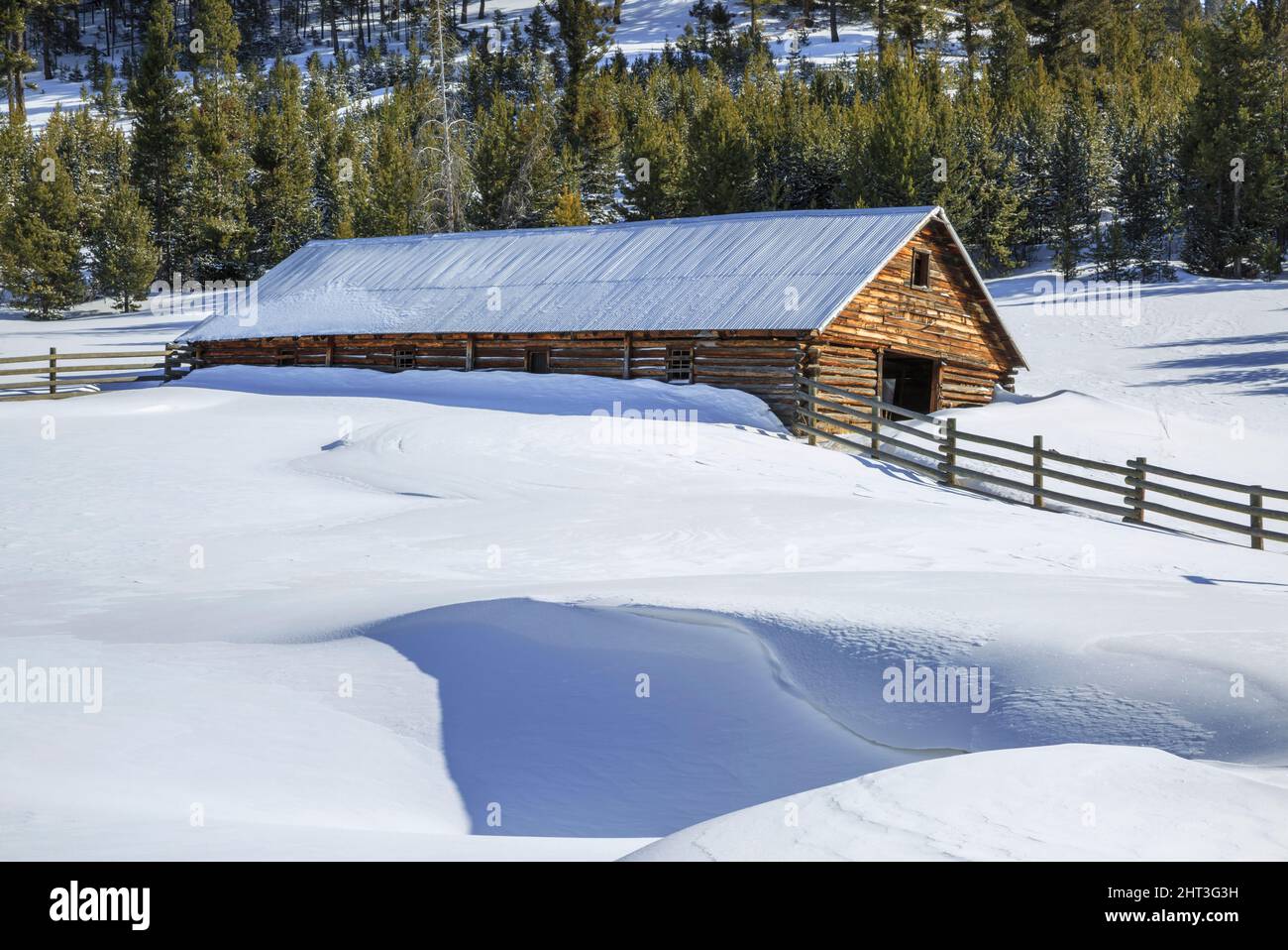 une ancienne grange en rondins et de profondes dérives de neige dans la vallée de dog creek près d'elliston, montana Banque D'Images