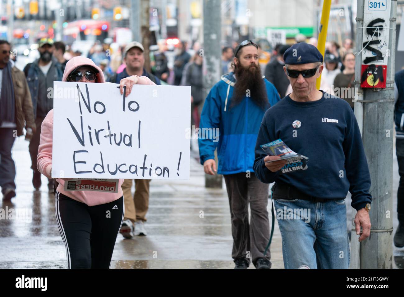 Une femme tenant et marchant avec un dire non à l'éducation virtuelle signe dans les rues de Toronto, Ontario Canada Banque D'Images