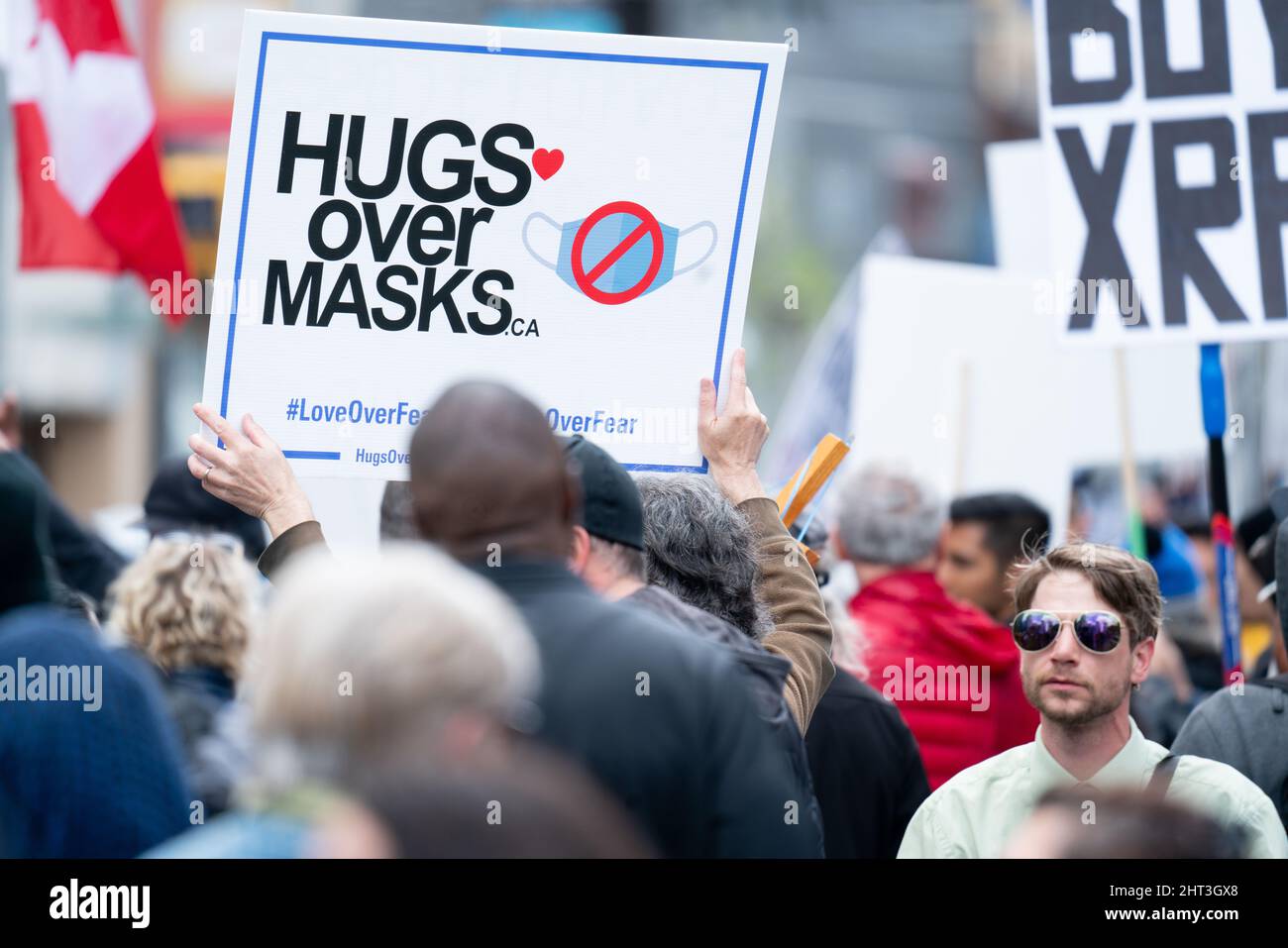 Des hugs au-dessus des masques signent une manifestation anti-masque lors du rassemblement Covid-19 à Toronto, Ontario, Canada Banque D'Images