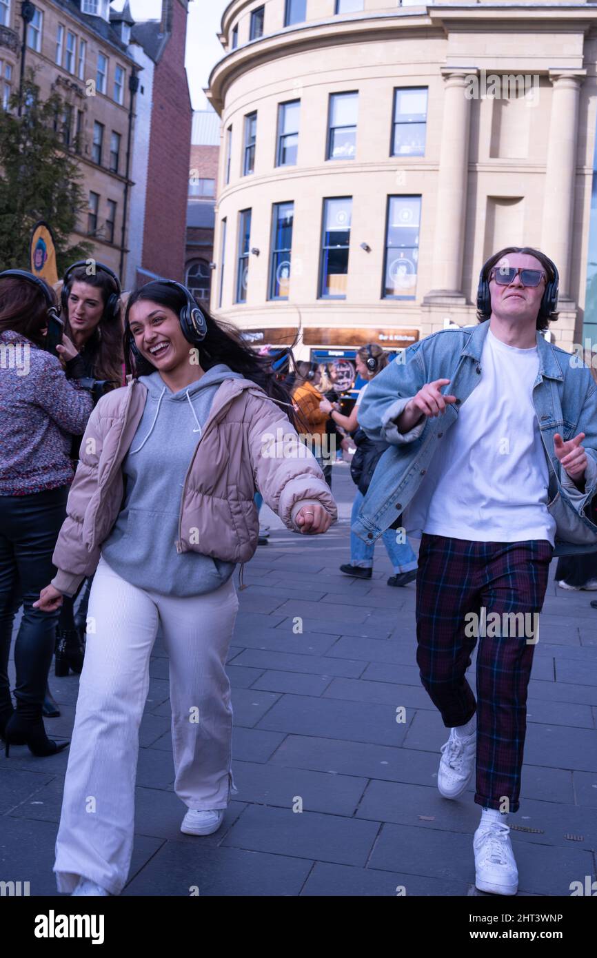 Culture britannique. Les personnes qui prennent part à une discothèque silencieuse en plein air, dans le centre-ville, au Monument à Newcastle upon Tyne, Royaume-Uni. Banque D'Images