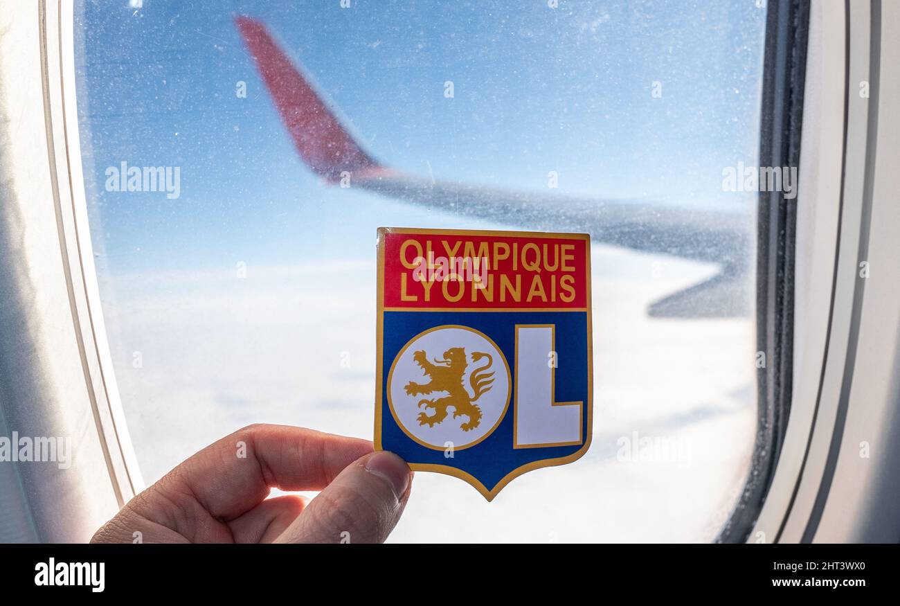 6 décembre 2021. Lyon, France. L'emblème du club de football Olympique Lyonnais sur le fond d'une fenêtre d'avion. Banque D'Images