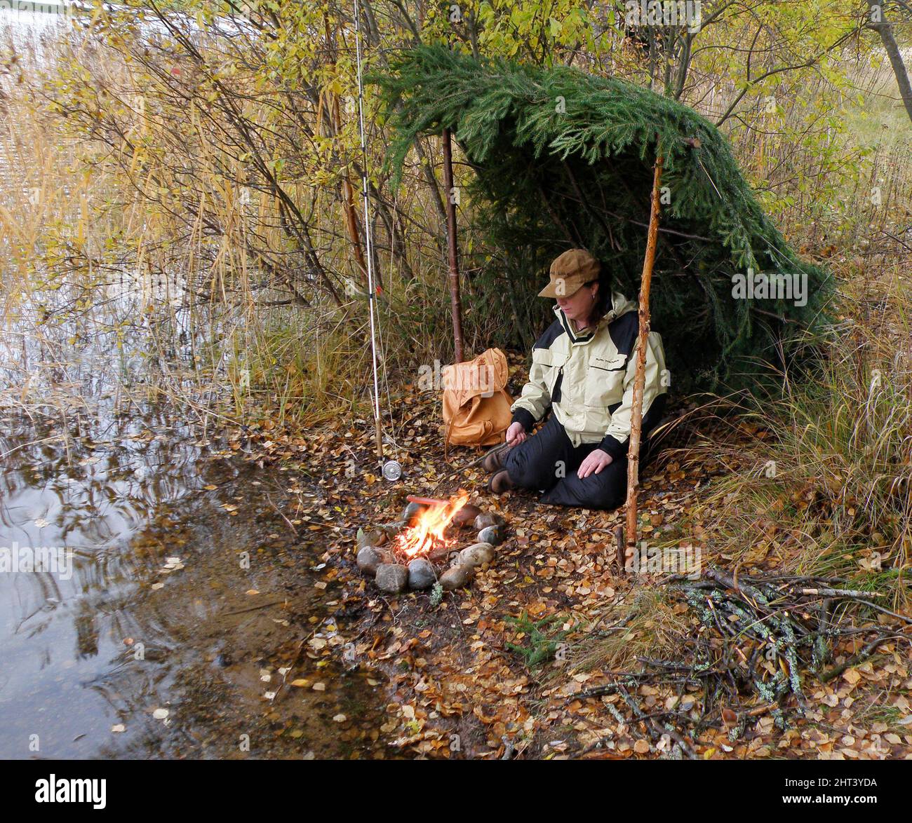 Femme prendre une pause de pêche sous la protection du vent de riz de sapin Banque D'Images