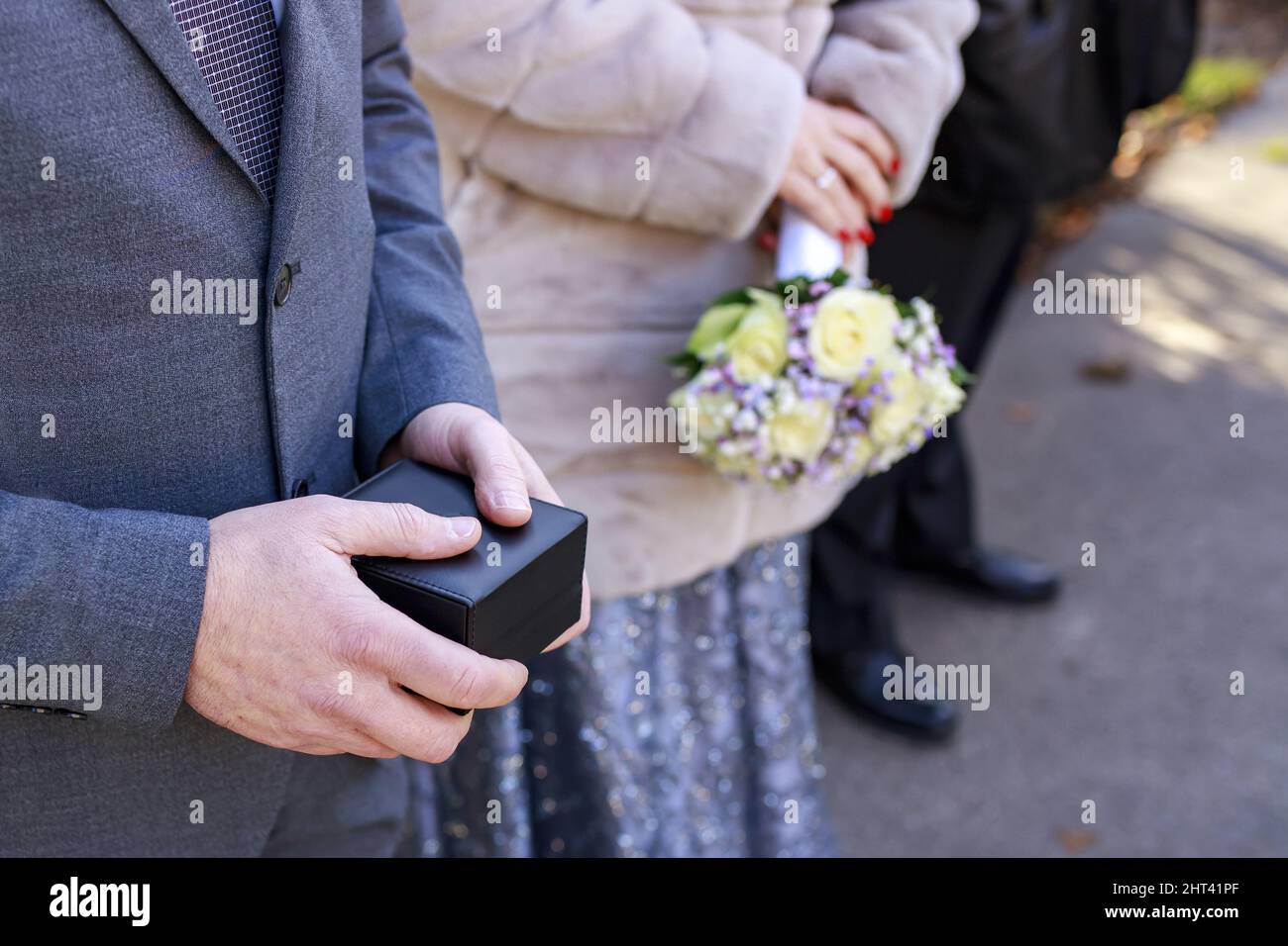 Gros plan d'un homme tenant une boîte à anneaux et d'une femme tenant des fleurs Banque D'Images