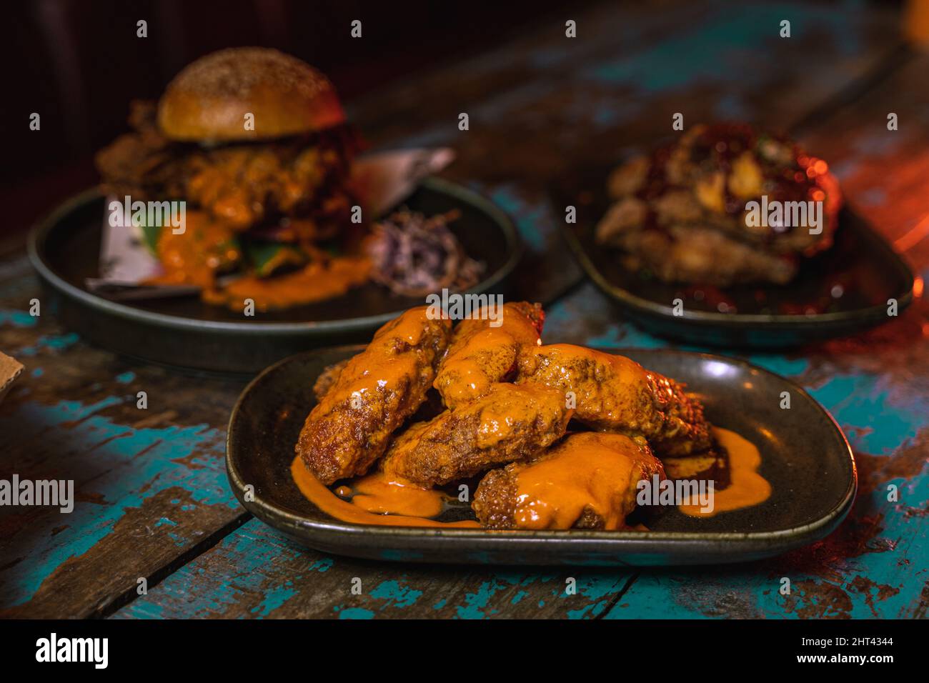 Un gros plan d'ailes de poulet dans un cadre de restaurant sombre et gundy Banque D'Images