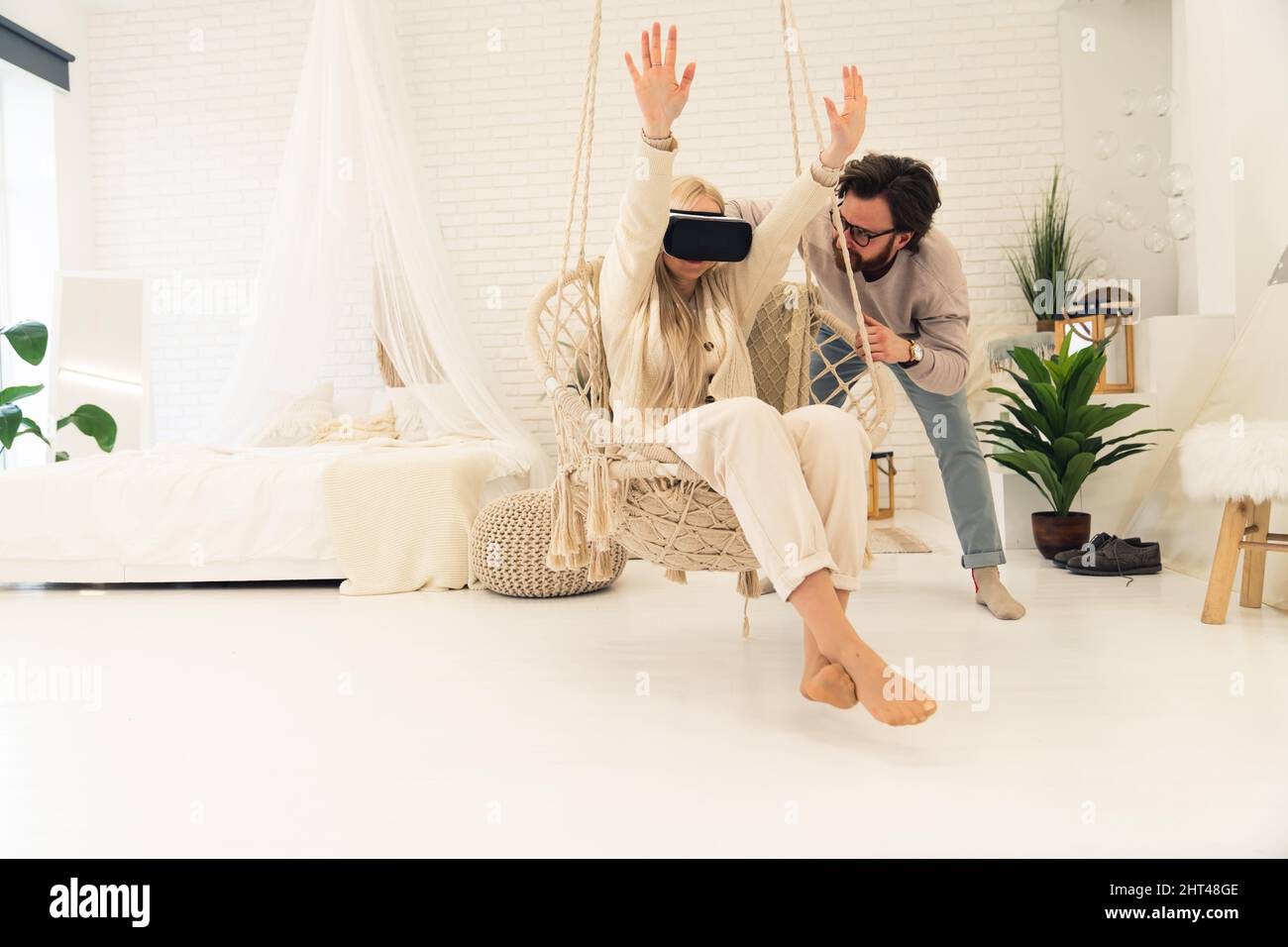jeune femme caucasienne commençant ses aventures avec des lunettes de réalité virtuelle avec l'aide de son mari. Photo de haute qualité Banque D'Images