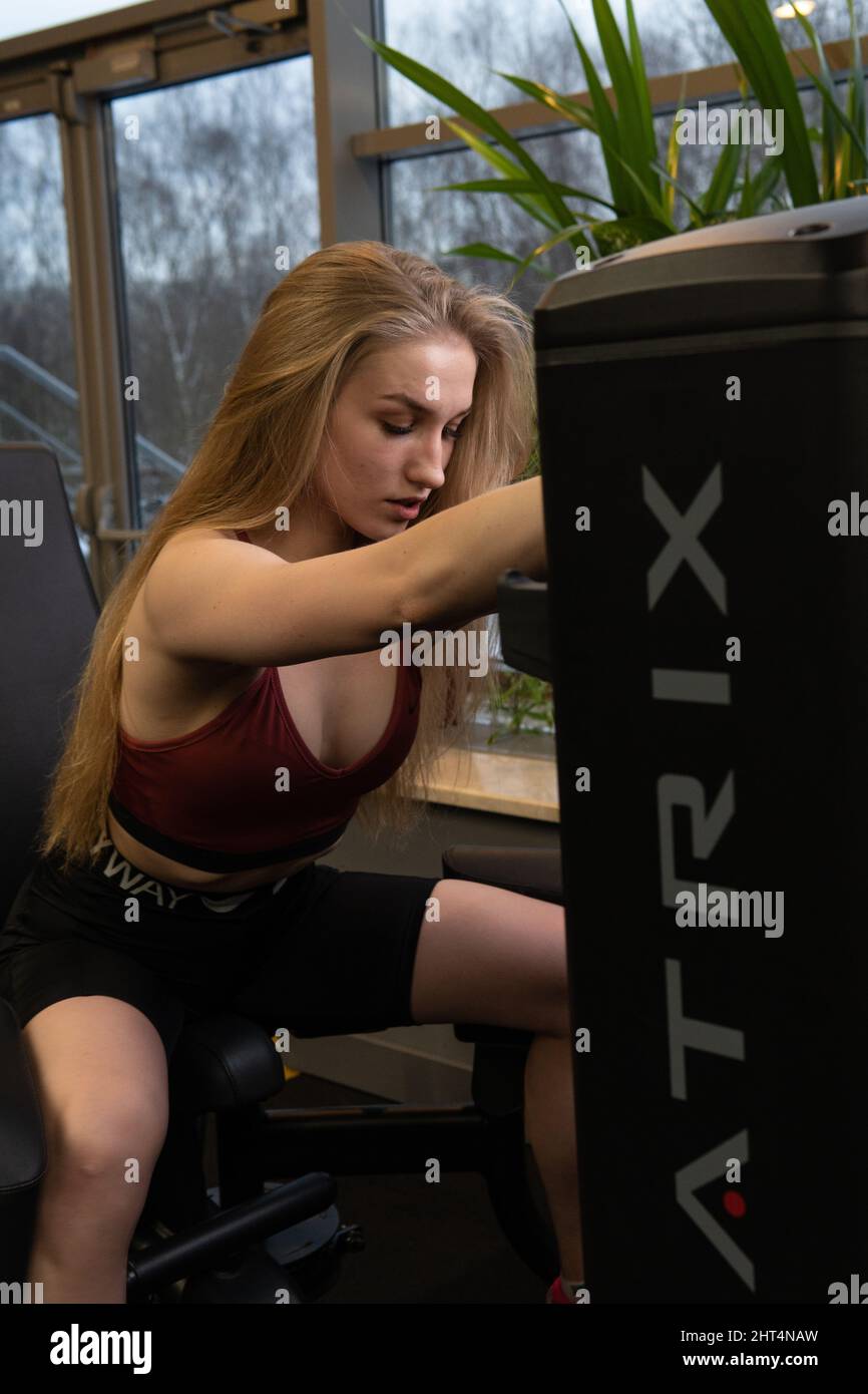 RUSSIE, MOSCOU - 11 FÉVRIER 2022: L'entraînement dirigé par un instructeur aide un beau client à effectuer des exercices dans un club de fitness, le concept de jouer du sport Banque D'Images