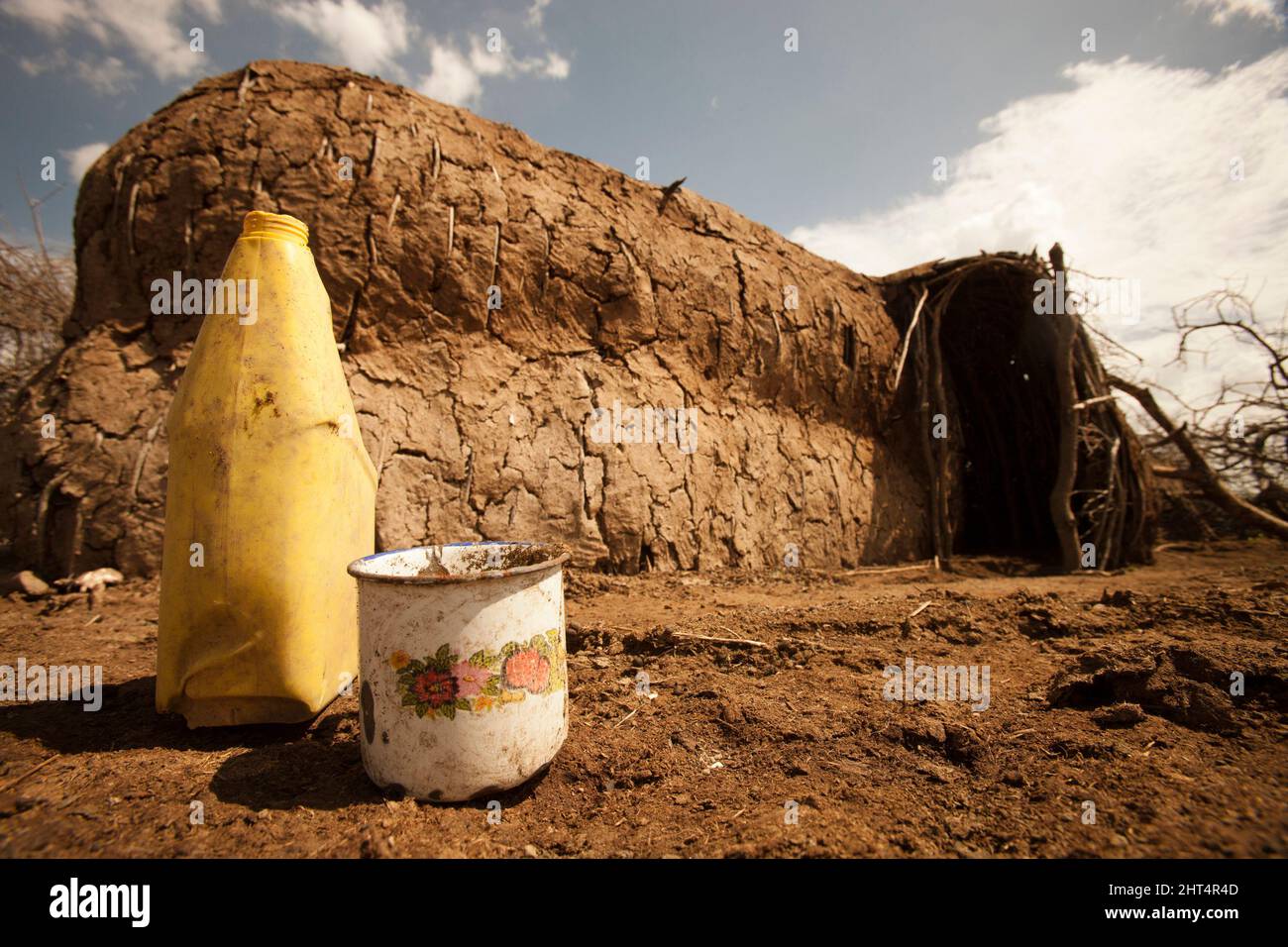 Un abri Maasai et une tasse en étain et un récipient à eau. Cette zone de conservation permet l'habitation humaine, contrairement à d'autres en Tanzanie. Région de Ndutu, Ngorongoro Co Banque D'Images