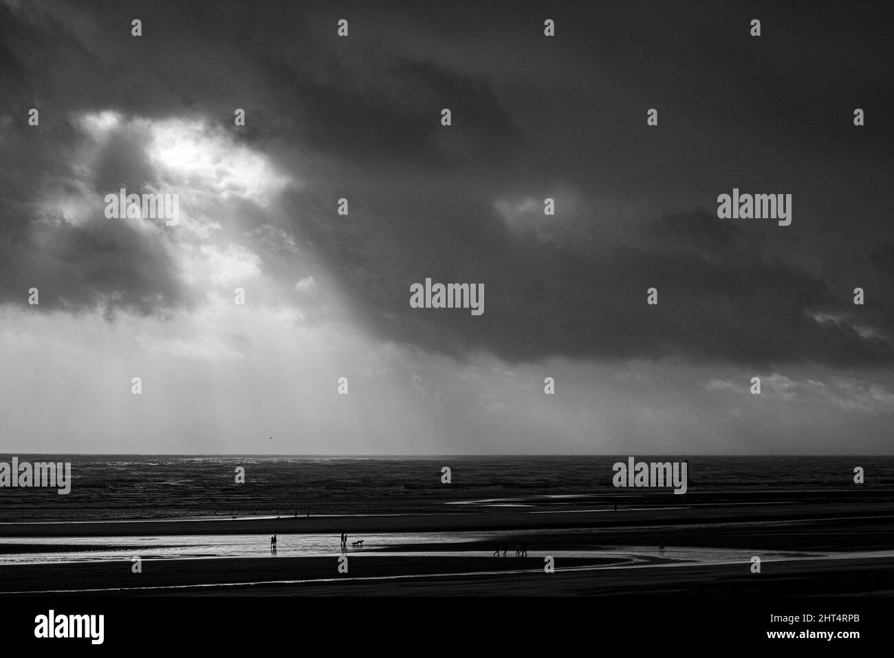 Prise de vue en niveaux de gris du Camber Sands entouré par la mer à Rye, Angleterre, Royaume-Uni Banque D'Images