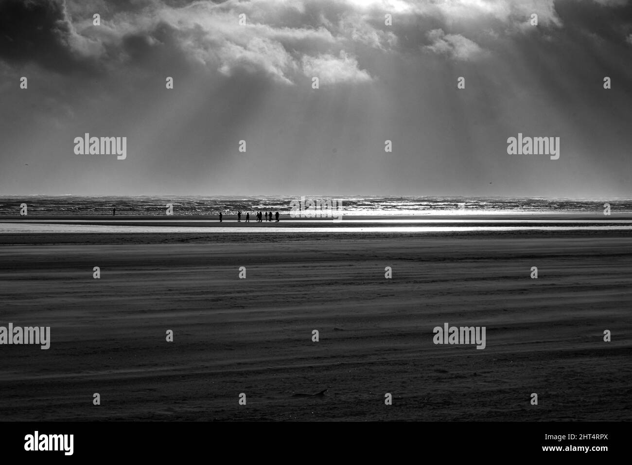 Prise de vue en niveaux de gris du Camber Sands entouré par la mer à Rye, Angleterre, Royaume-Uni Banque D'Images