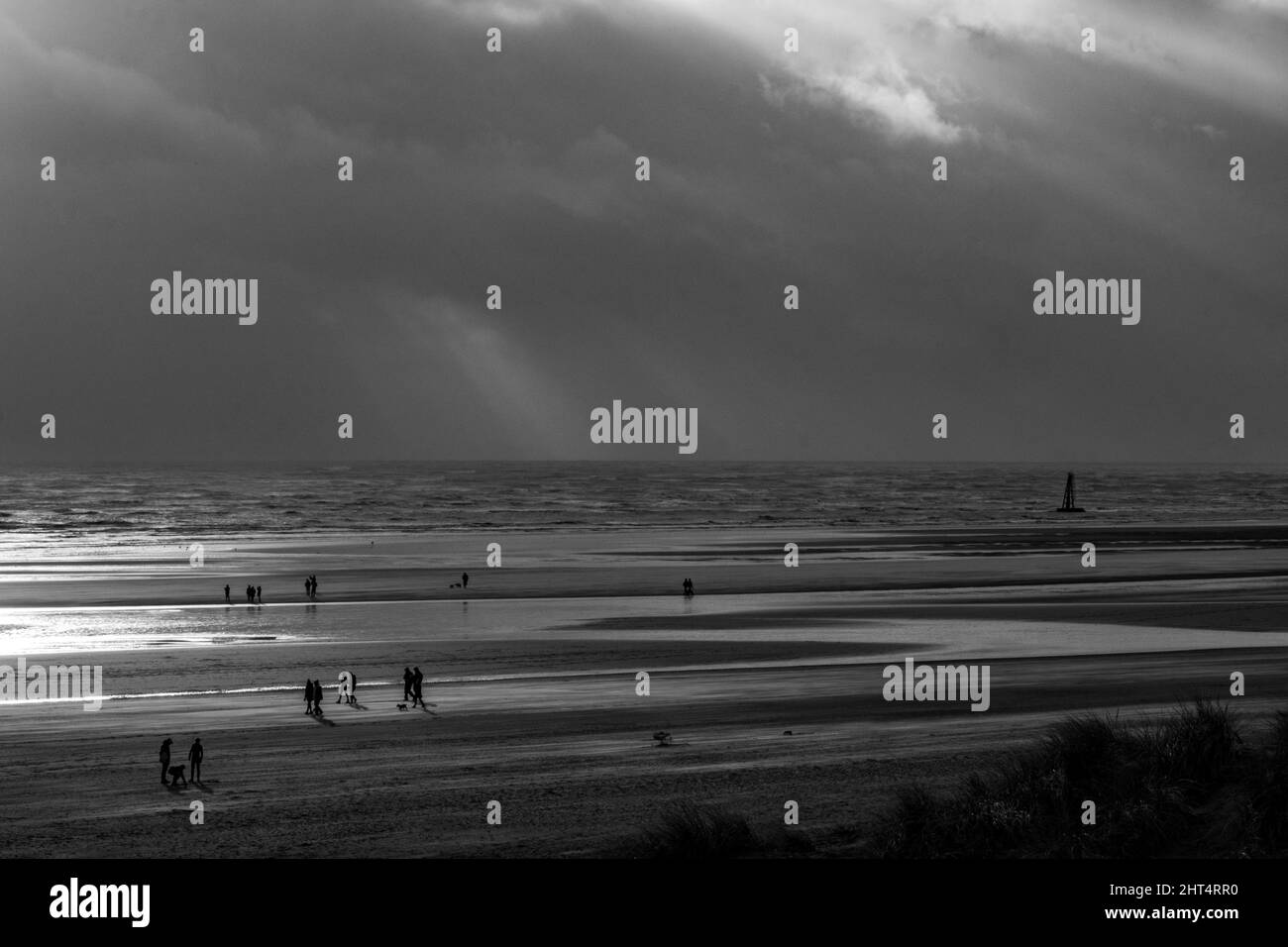 Prise de vue en niveaux de gris du Camber Sands entouré par la mer à Rye, Angleterre, Royaume-Uni Banque D'Images