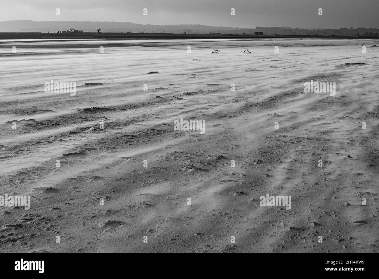 Prise de vue en niveaux de gris du Camber Sands entouré par la mer à Rye, Angleterre, Royaume-Uni Banque D'Images