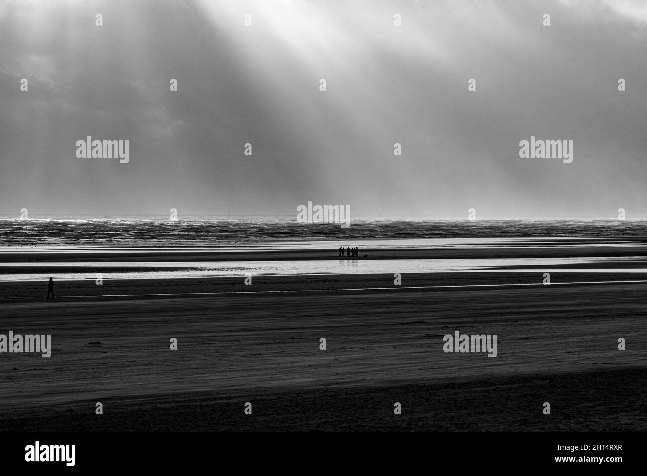 Prise de vue en niveaux de gris du Camber Sands entouré par la mer à Rye, Angleterre, Royaume-Uni Banque D'Images