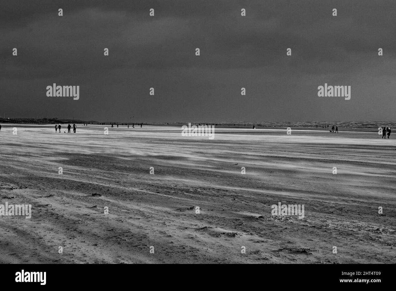 Prise de vue en niveaux de gris du Camber Sands entouré par la mer à Rye, Angleterre, Royaume-Uni Banque D'Images