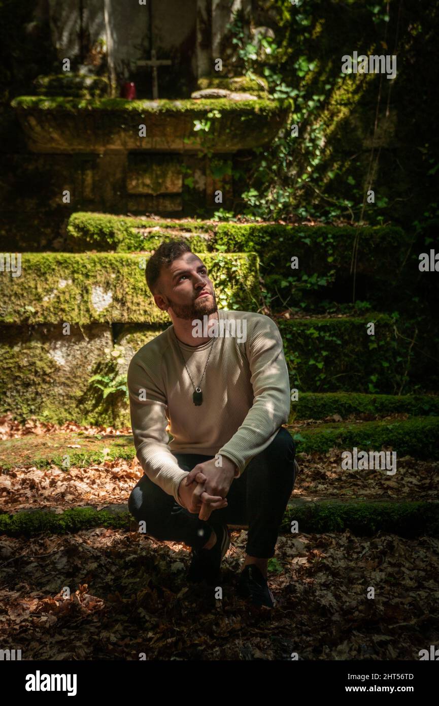 Jeune Espagnol regardant vers le haut à l'extérieur de l'église abandonnée au milieu de la montagne Banque D'Images