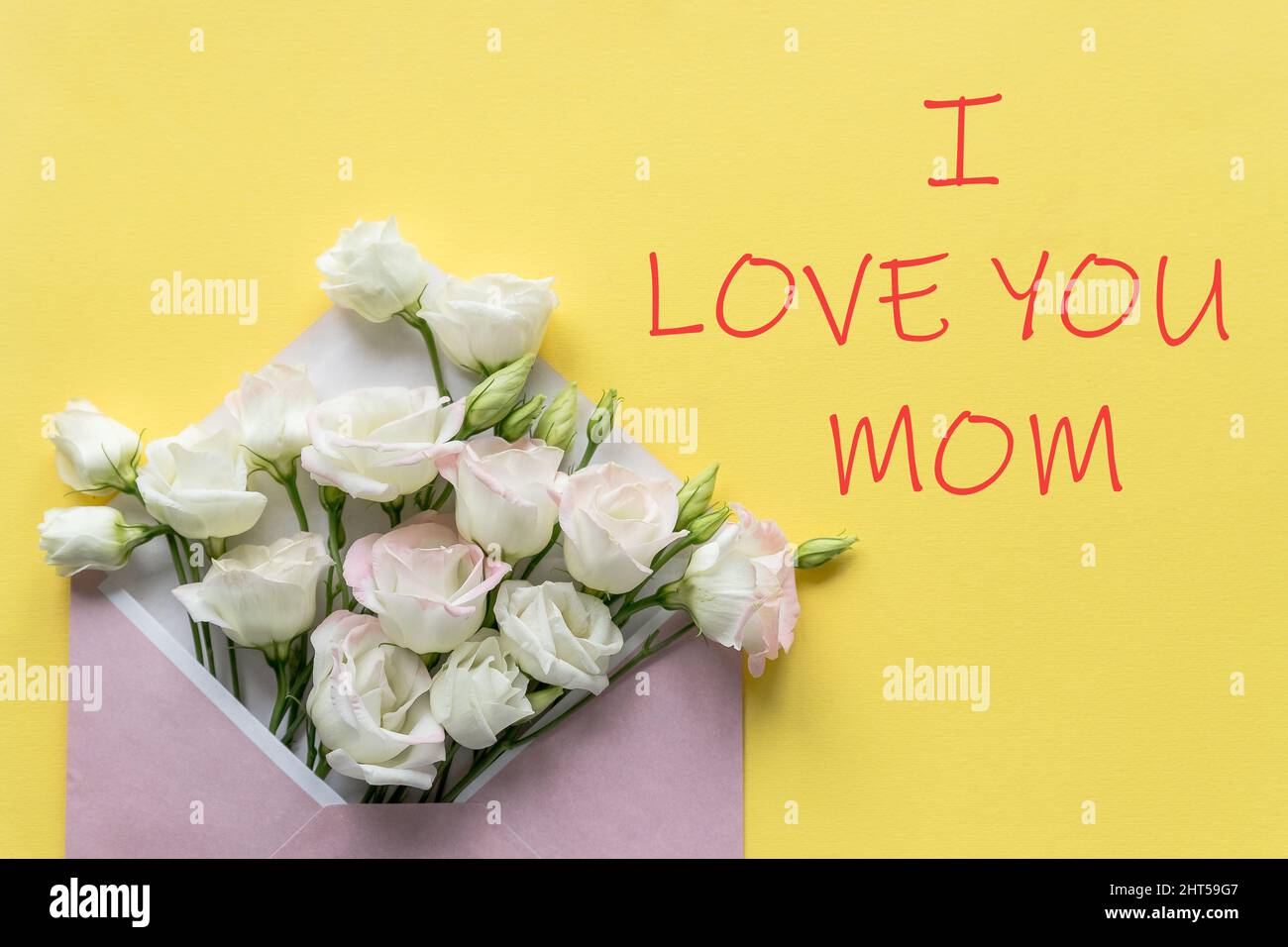 Joyeux cadeau de fête des mères avec fleurs roses dans une enveloppe pour les vacances sur fond jaune.carte de vœux avec fleurs d'eustoma blanches Banque D'Images