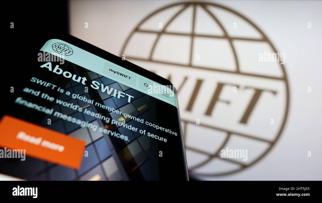 Téléphone mobile avec page Web du système de transaction bancaire SWIFT à l'écran devant le logo. Faites la mise au point dans le coin supérieur gauche de l'écran du téléphone. Banque D'Images