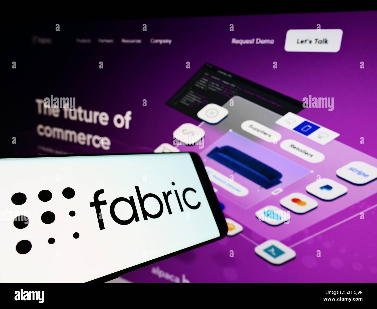 Téléphone portable avec logo de la société américaine de logiciels Commerce Fabric Inc. À l'écran devant le site Web d'affaires. Concentrez-vous sur le centre de l'écran du téléphone. Banque D'Images