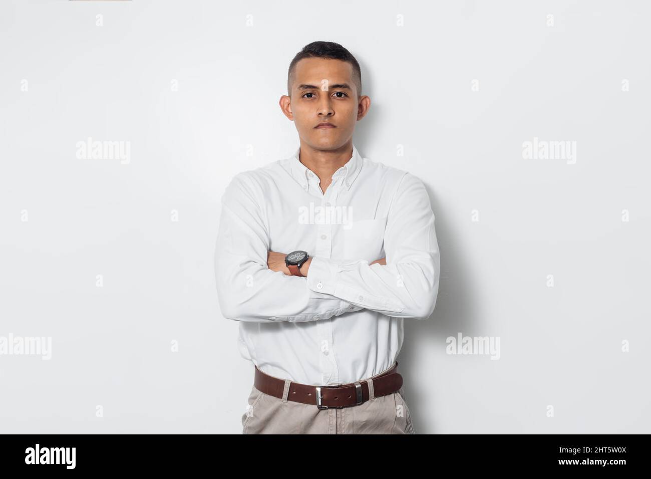 Un homme d'affaires latino-américain portant une chemise avec le mur blanc en arrière-plan Banque D'Images