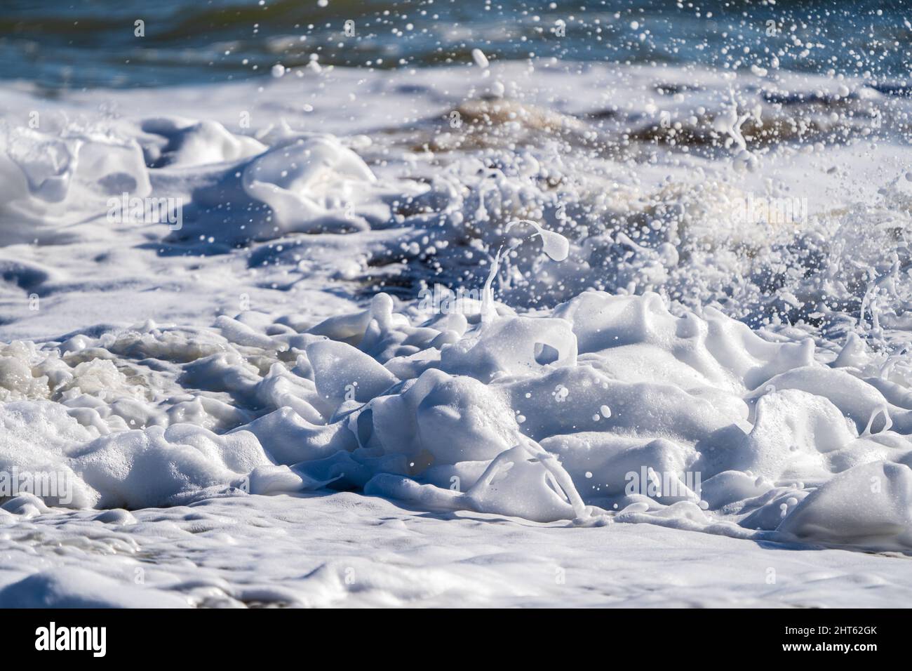 Vagues se brisant sur la plage avec de la mousse de mer Banque D'Images