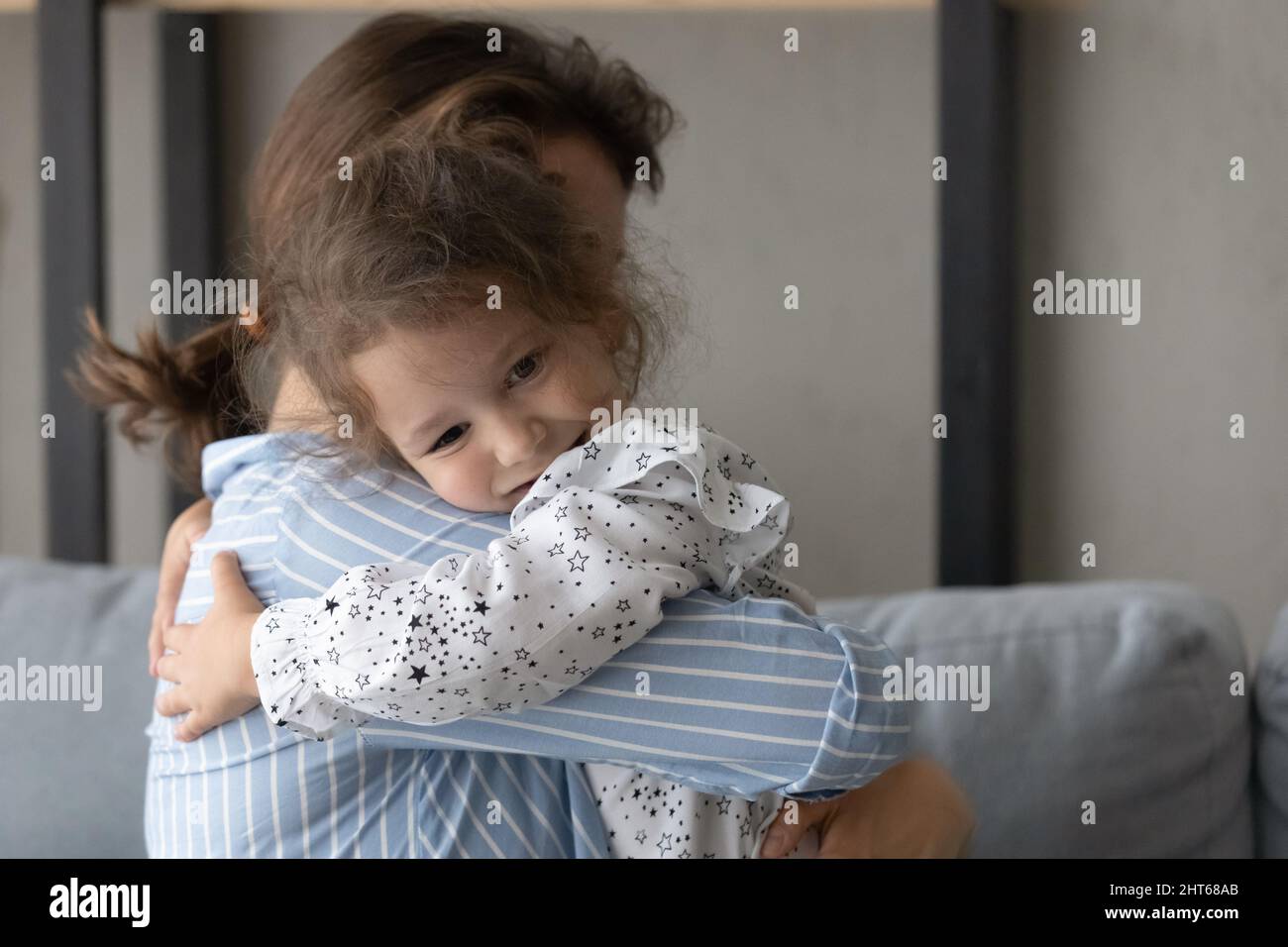 Petite fille souriante en cuddling aimante jeune mère. Banque D'Images