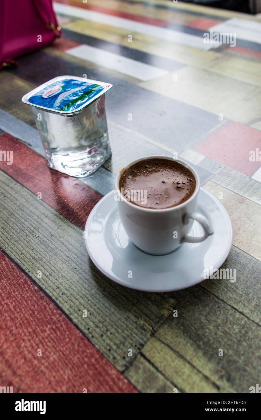 Café turc riche et hautement caféiné dans une tasse traditionnelle et une tasse en plastique d'eau sur une table Banque D'Images