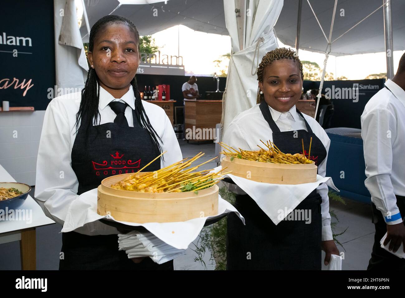 Serveurs féminins avec plats sur plateaux dans un salon VIP à Johannesburg, Afrique du Sud Banque D'Images
