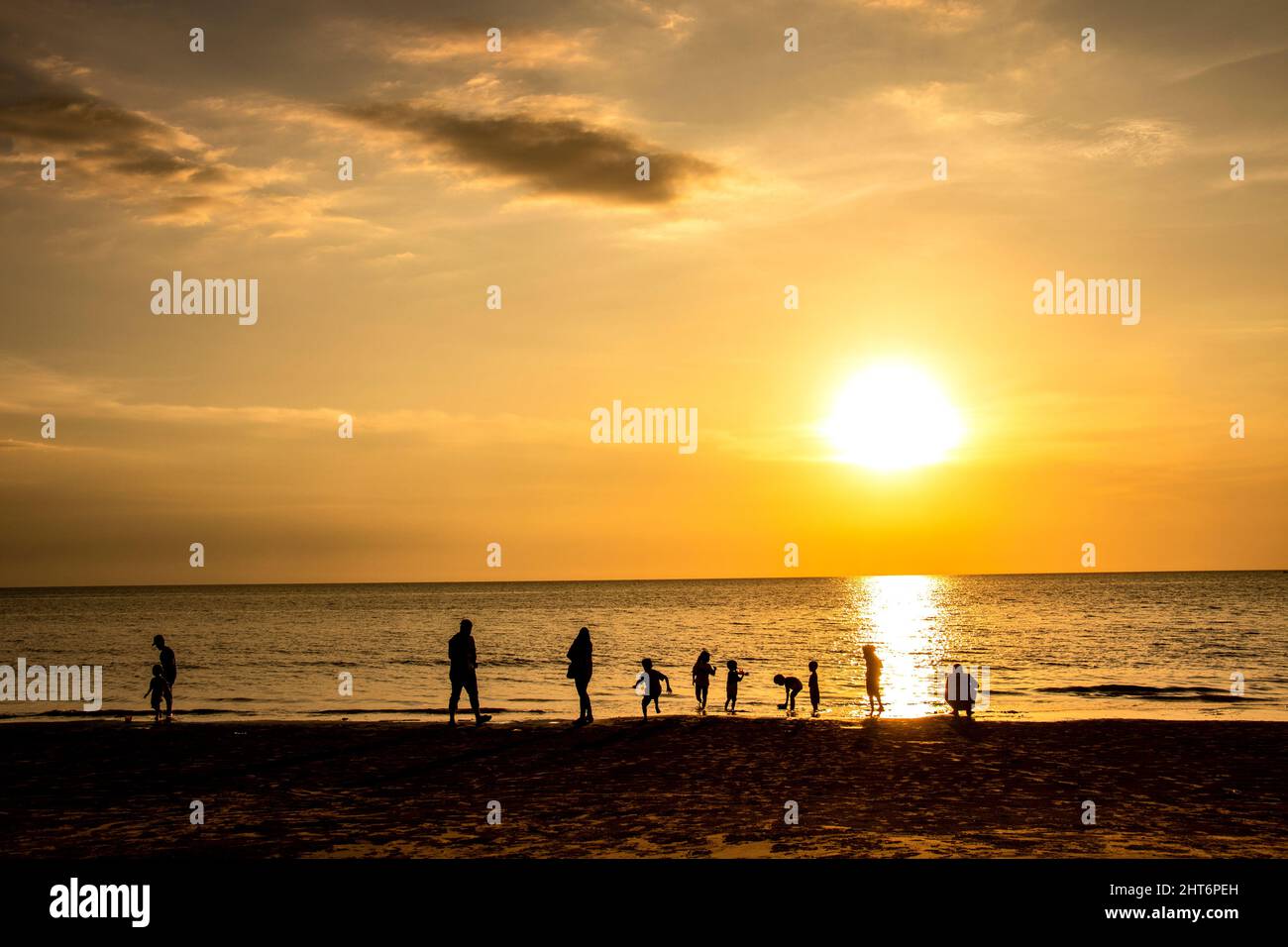 Familles et couples profitant du coucher du soleil sur la plage de Tajung Aru Sabah Bornéo Malaisie Banque D'Images