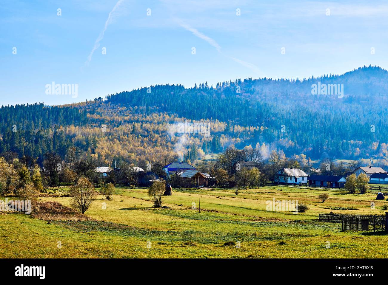 Chaîne de montagnes et village aux couleurs automnales et ciel bleu Banque D'Images