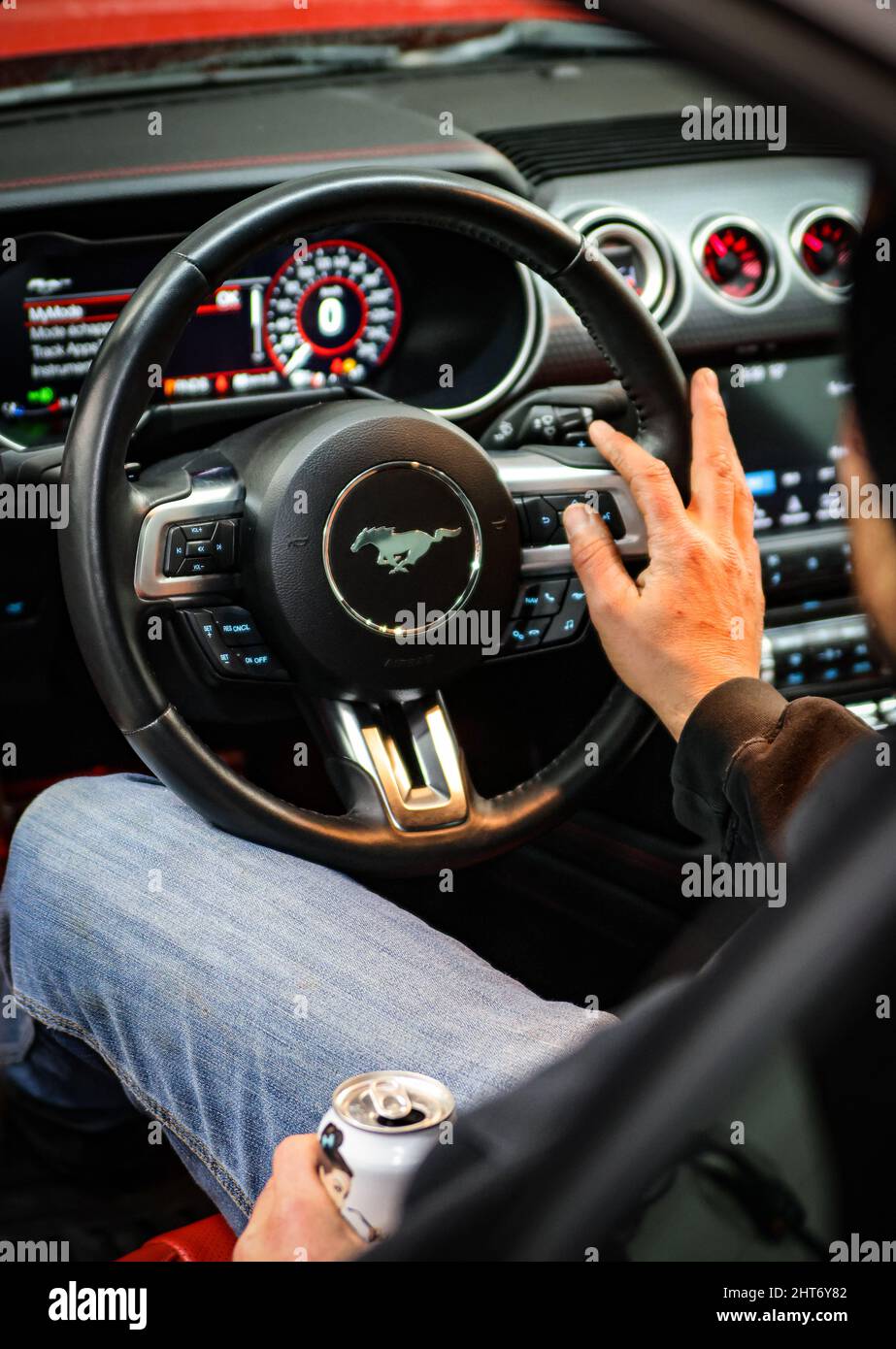 Un homme dans une nouvelle Ford Mustang rouge Banque D'Images