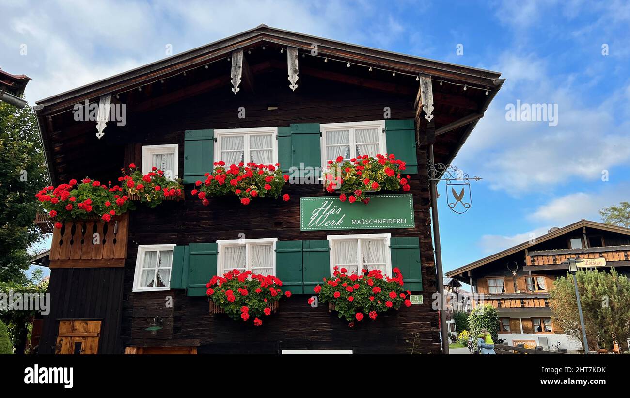 Un gros plan d'un petit bâtiment en bois avec des fleurs décoratives sur le mur dans la campagne Banque D'Images