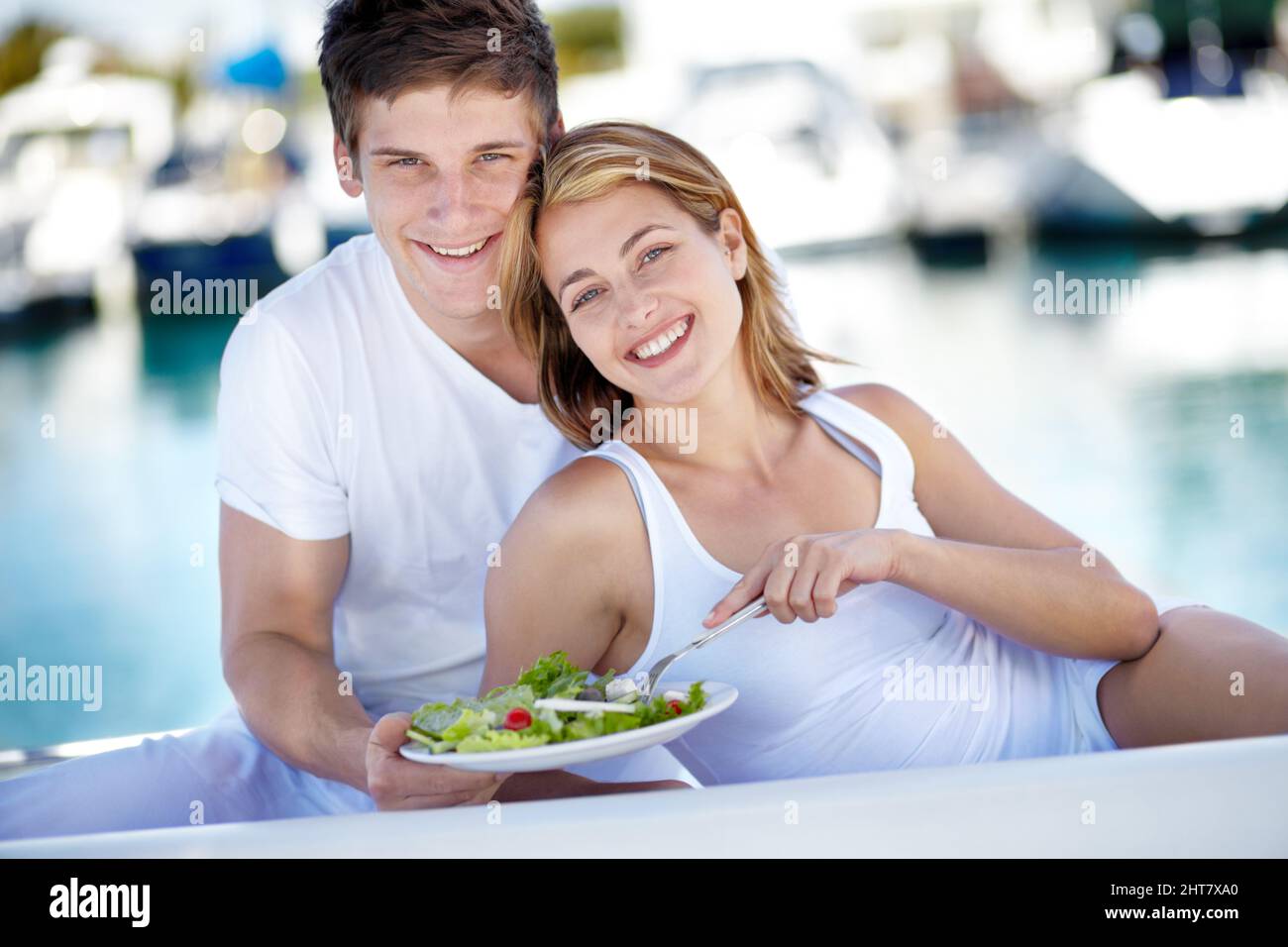 Partager un style de vie sain. Jeune couple appréciant une salade fraîche ensemble. Banque D'Images