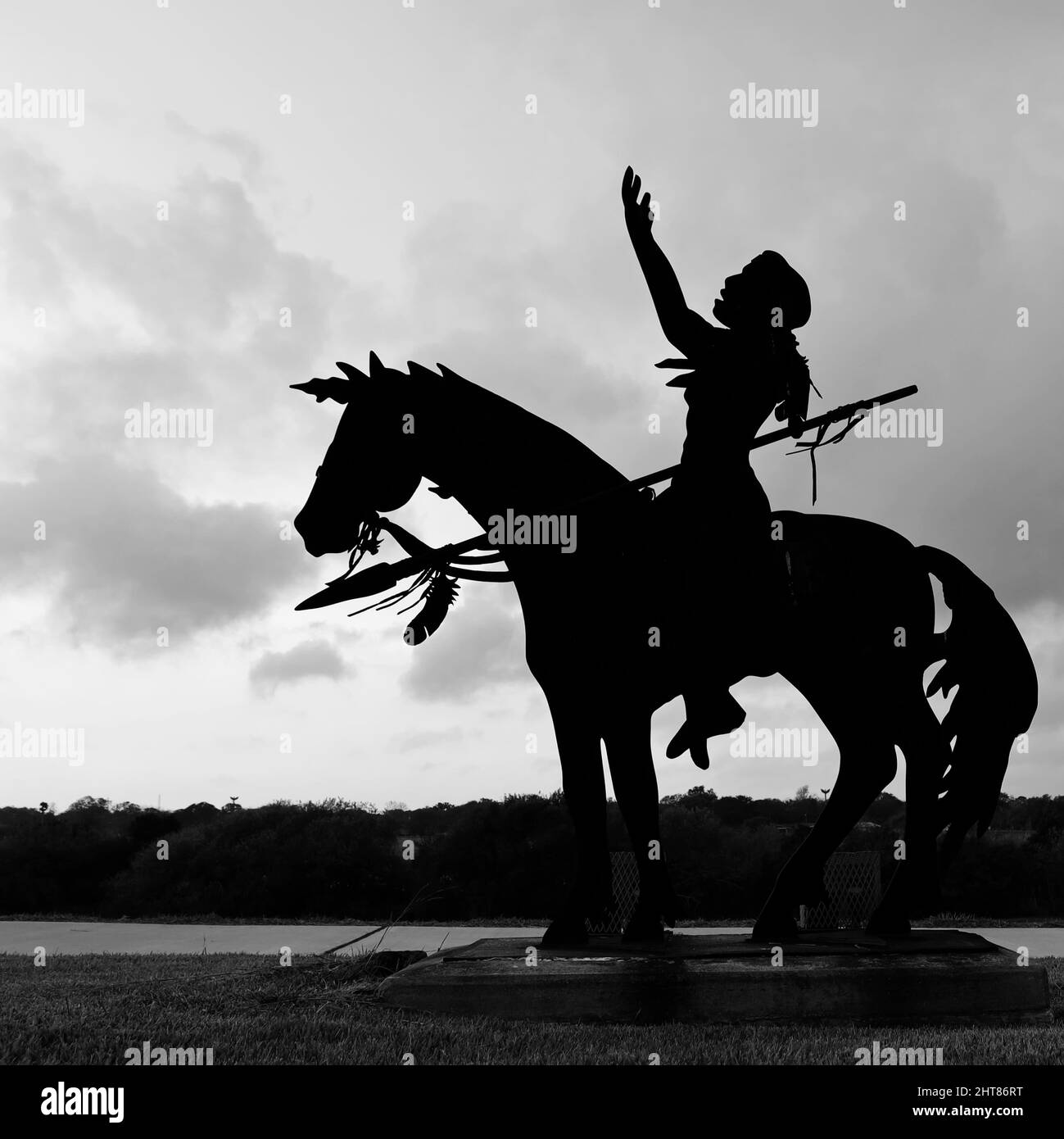 Silhouette de la statue d'une personne amérindienne sur un cheval contre un ciel nuageux Banque D'Images