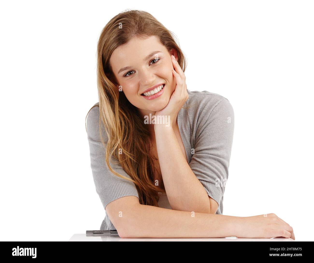 Heureux et content. Portrait en studio d'une jeune femme attrayante avec sa tête sur sa main sur un fond blanc. Banque D'Images